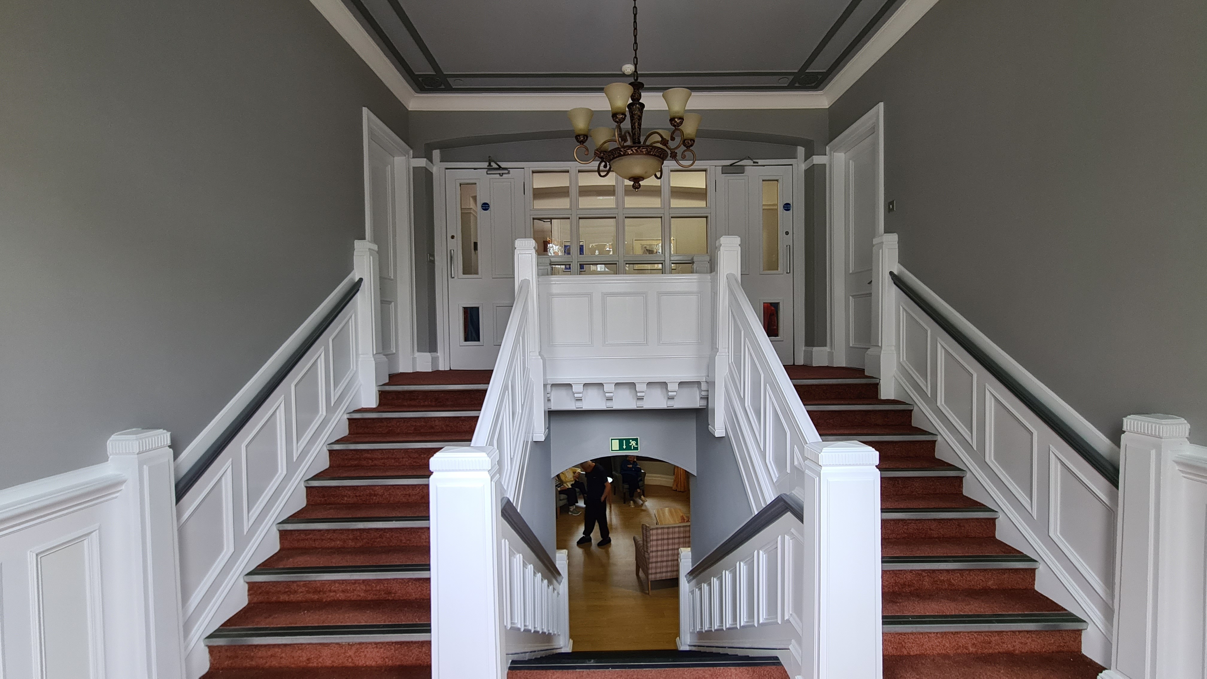 A set of stairs leading to a small landing and doors