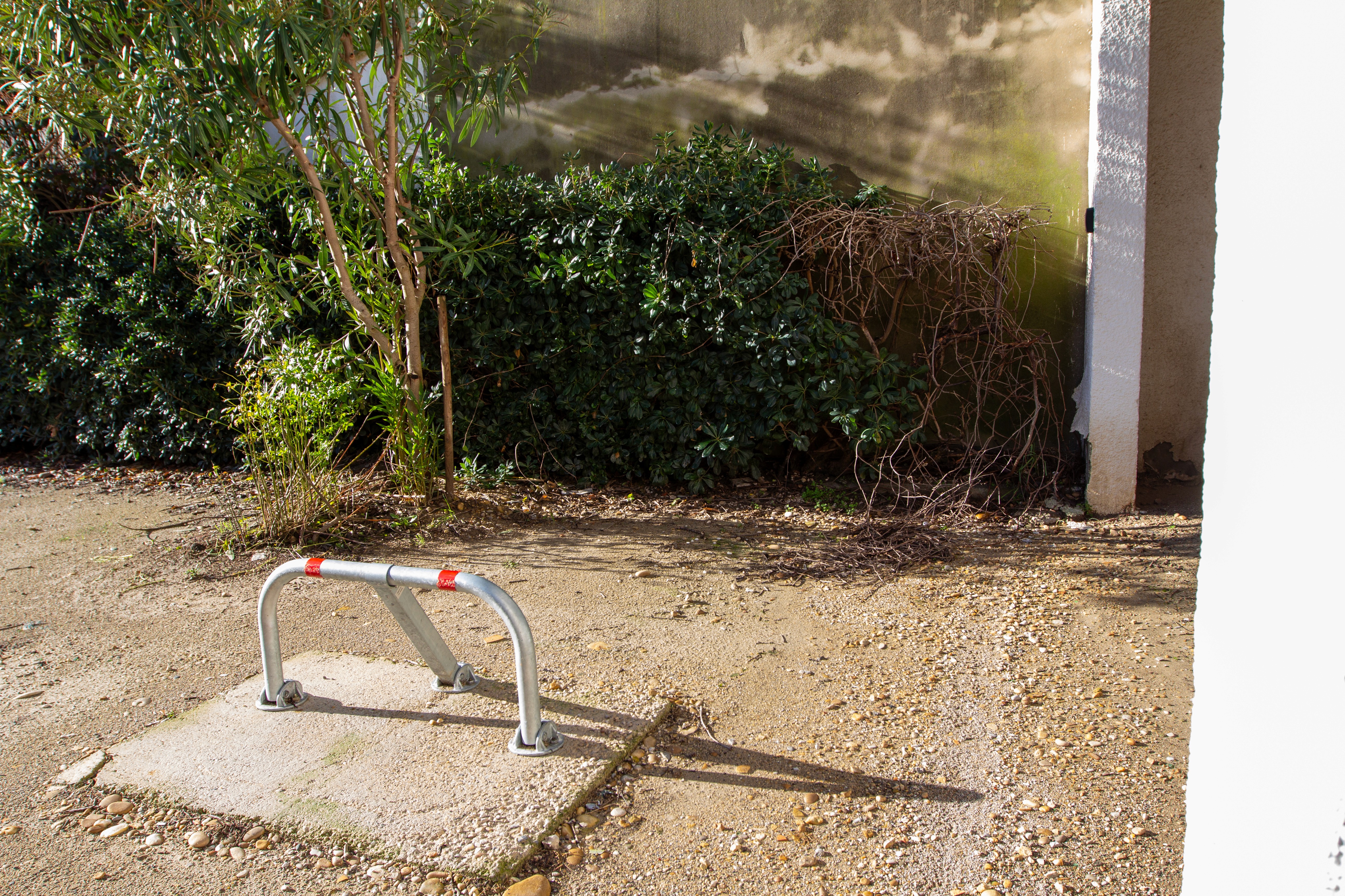 Place de parking privée sécurisée avec arceau de stationnement réservée aux voyageurs devant le logement.
