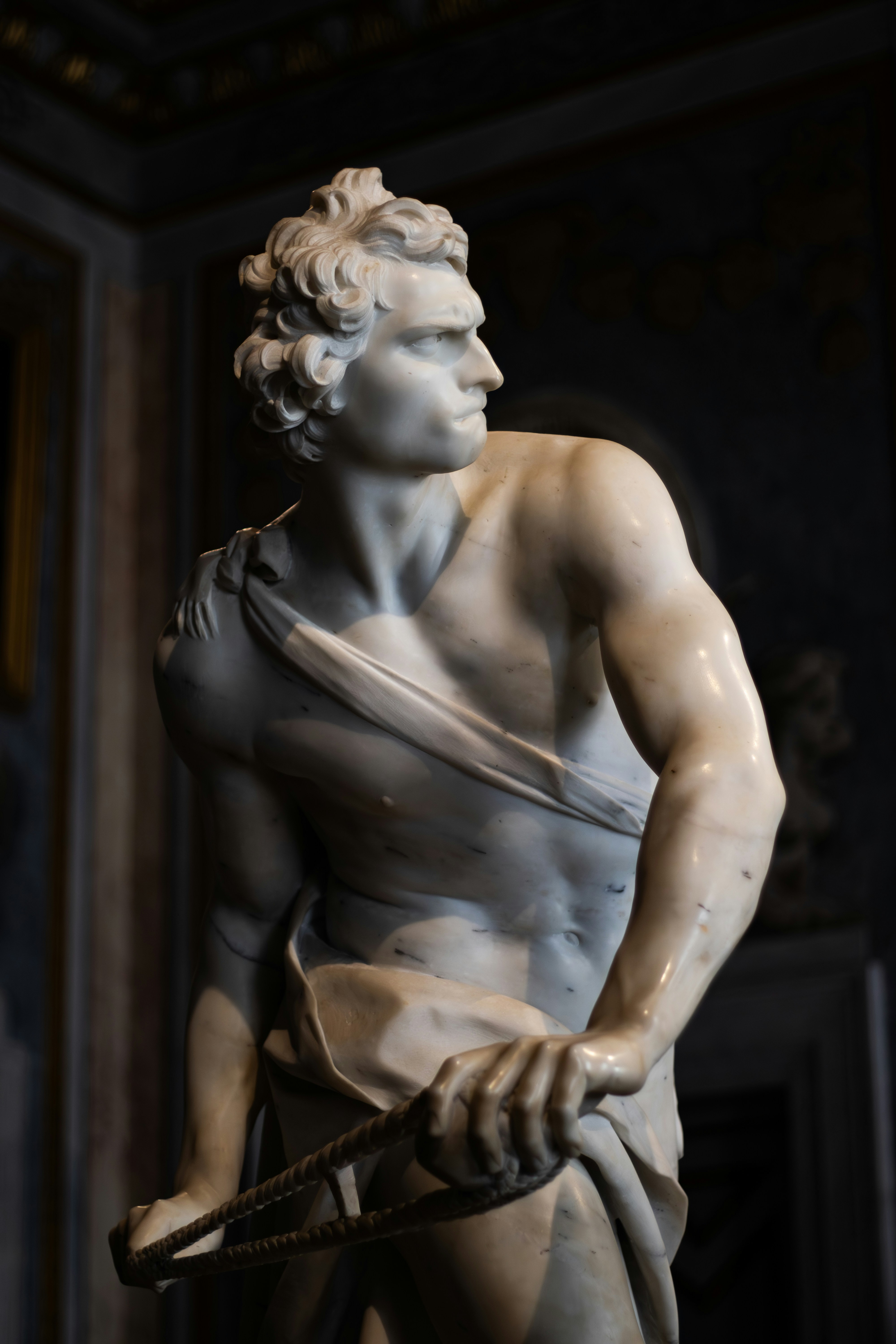 Marble statue of a muscular man holding rope