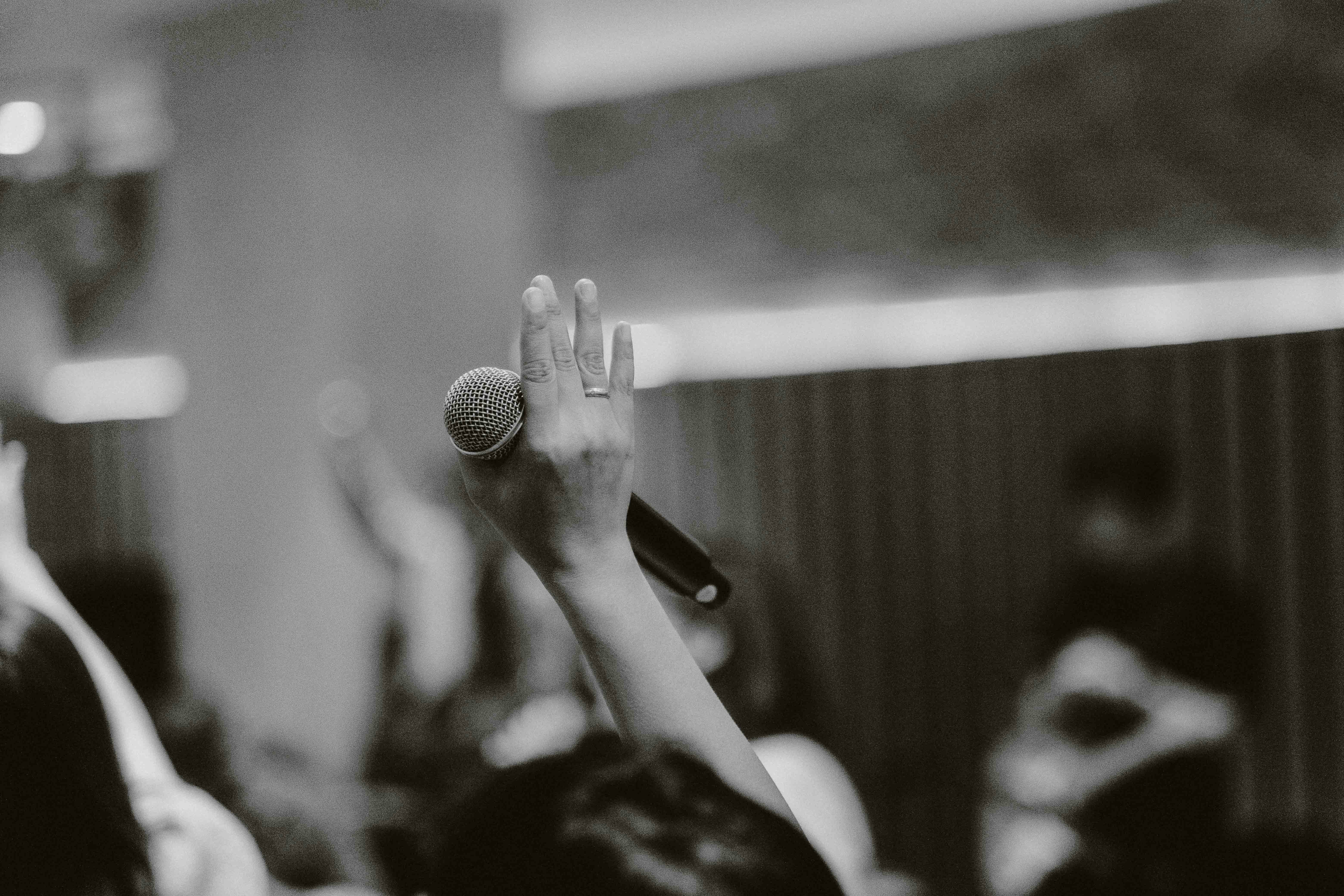 a black and white photo of a person holding a microphone