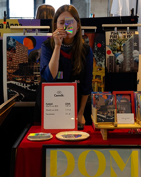 Zdjęcie przedstawiające artystkę na stanowisku targowym.