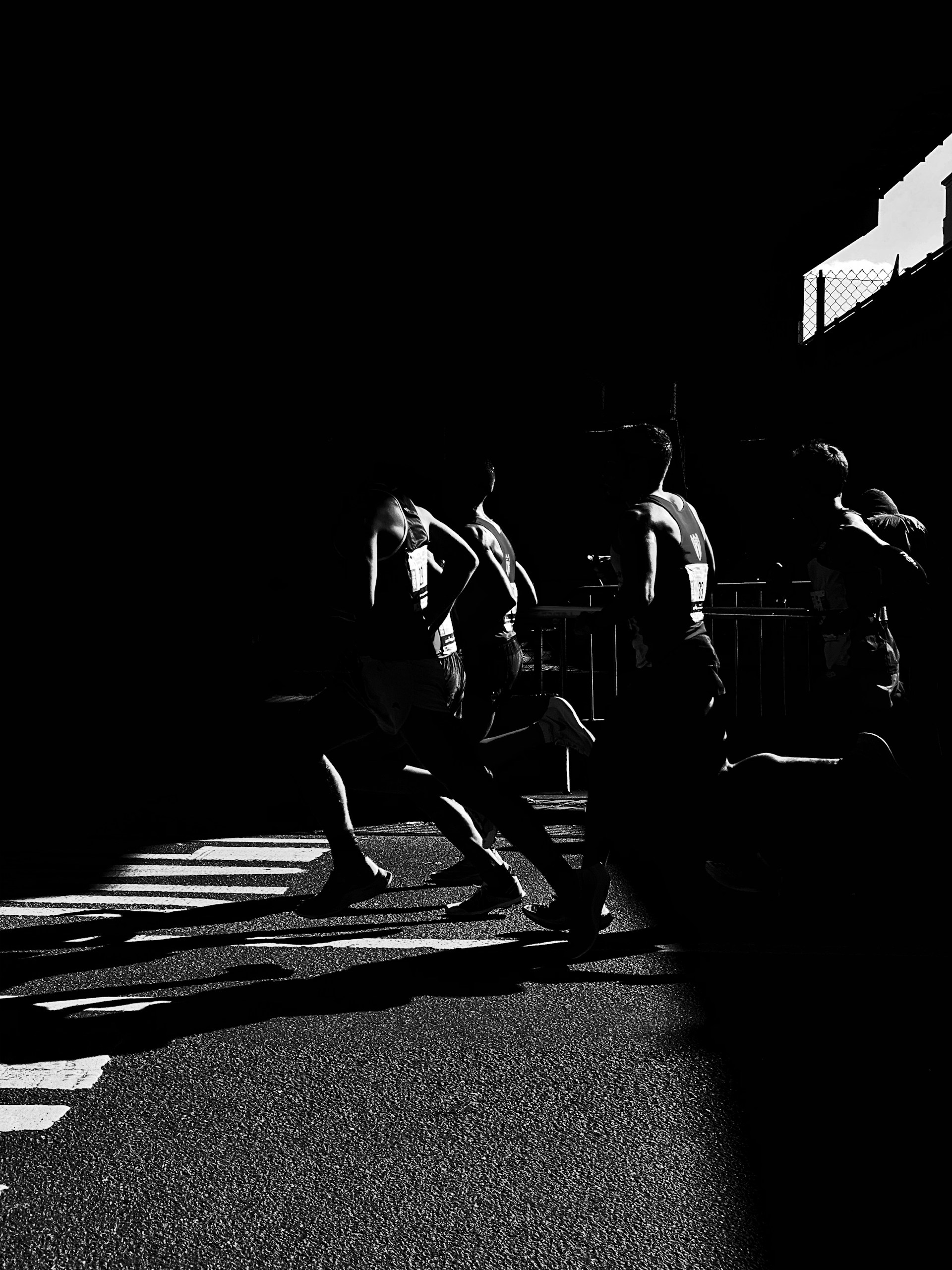 Group of runners racing on a city street, highlighting the physical demands of road running.