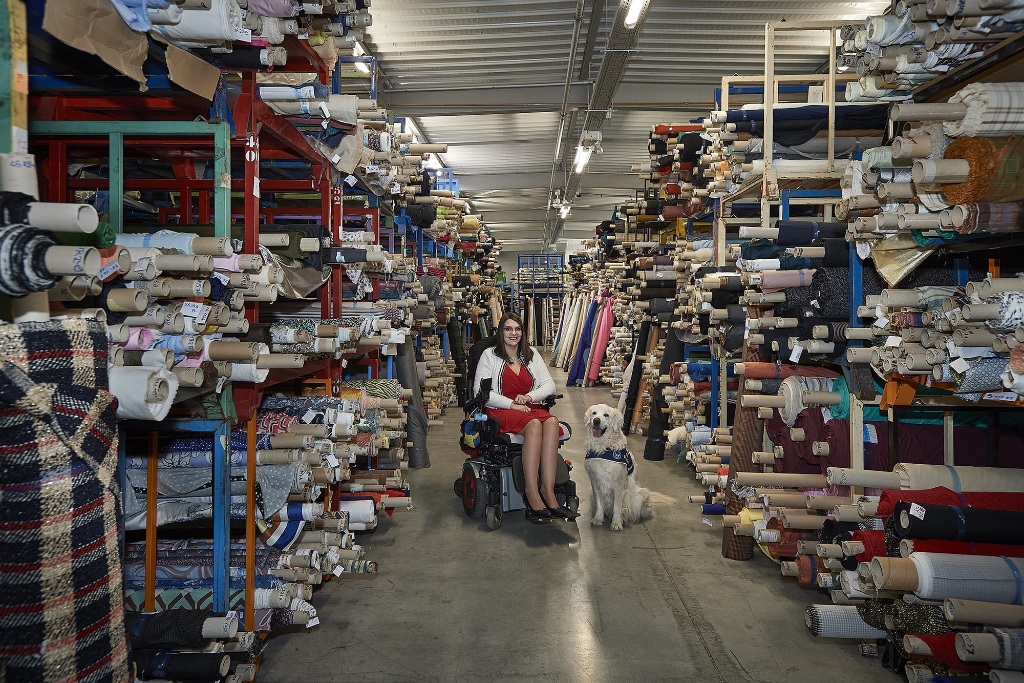 Émilie accompagnée de son chien d’assistance Jeep, photographiées par Frédéric Bourcier à la société Beglarian Fabrics à Gleizé dans le cadre d’un reportage documentaire social pour Handi’Chiens.