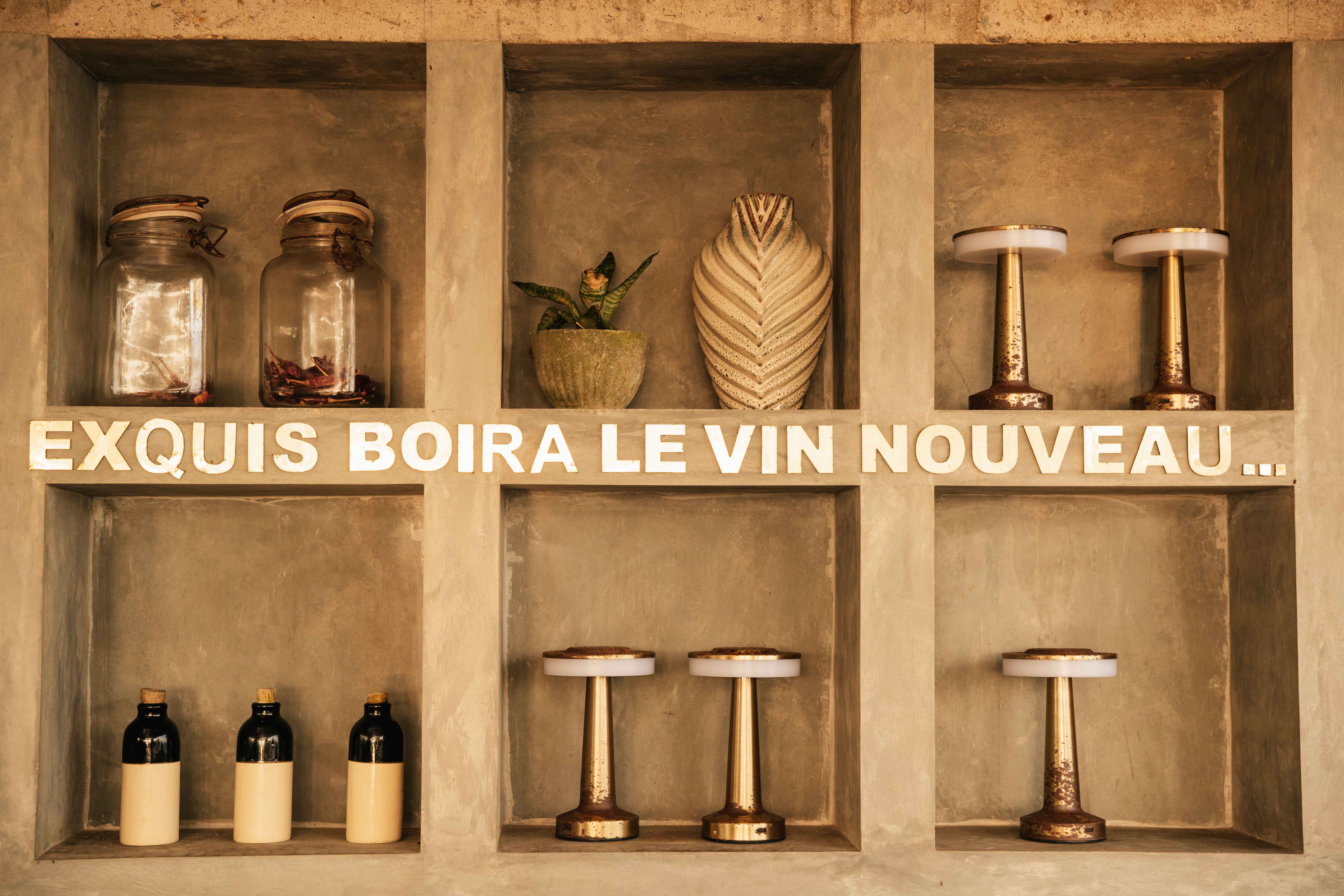 Bar aesthetic of beige wall with lamps, vases and glases inside