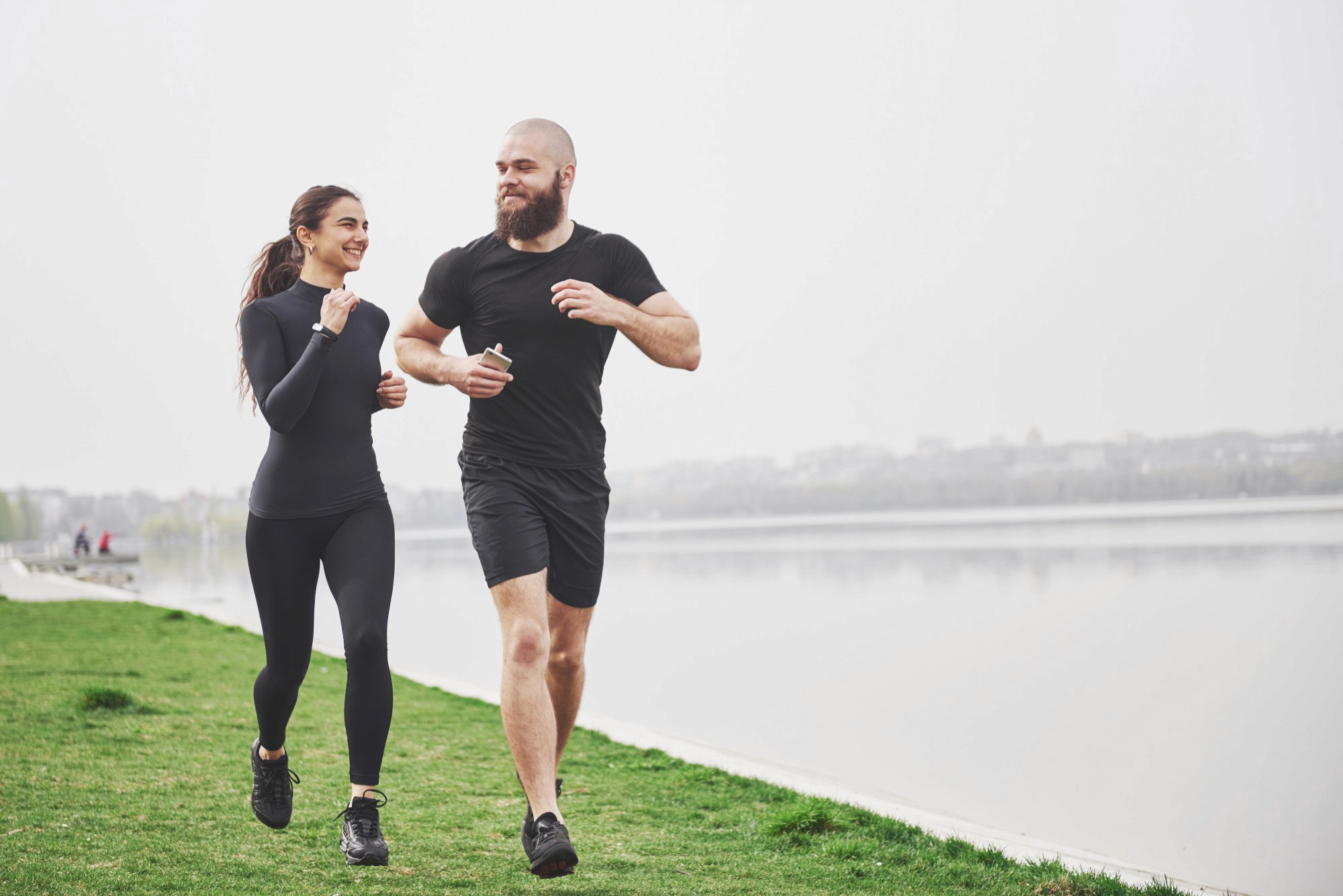 Couple jogging by a riverside, representing active living and holistic health with Lumyn Health.