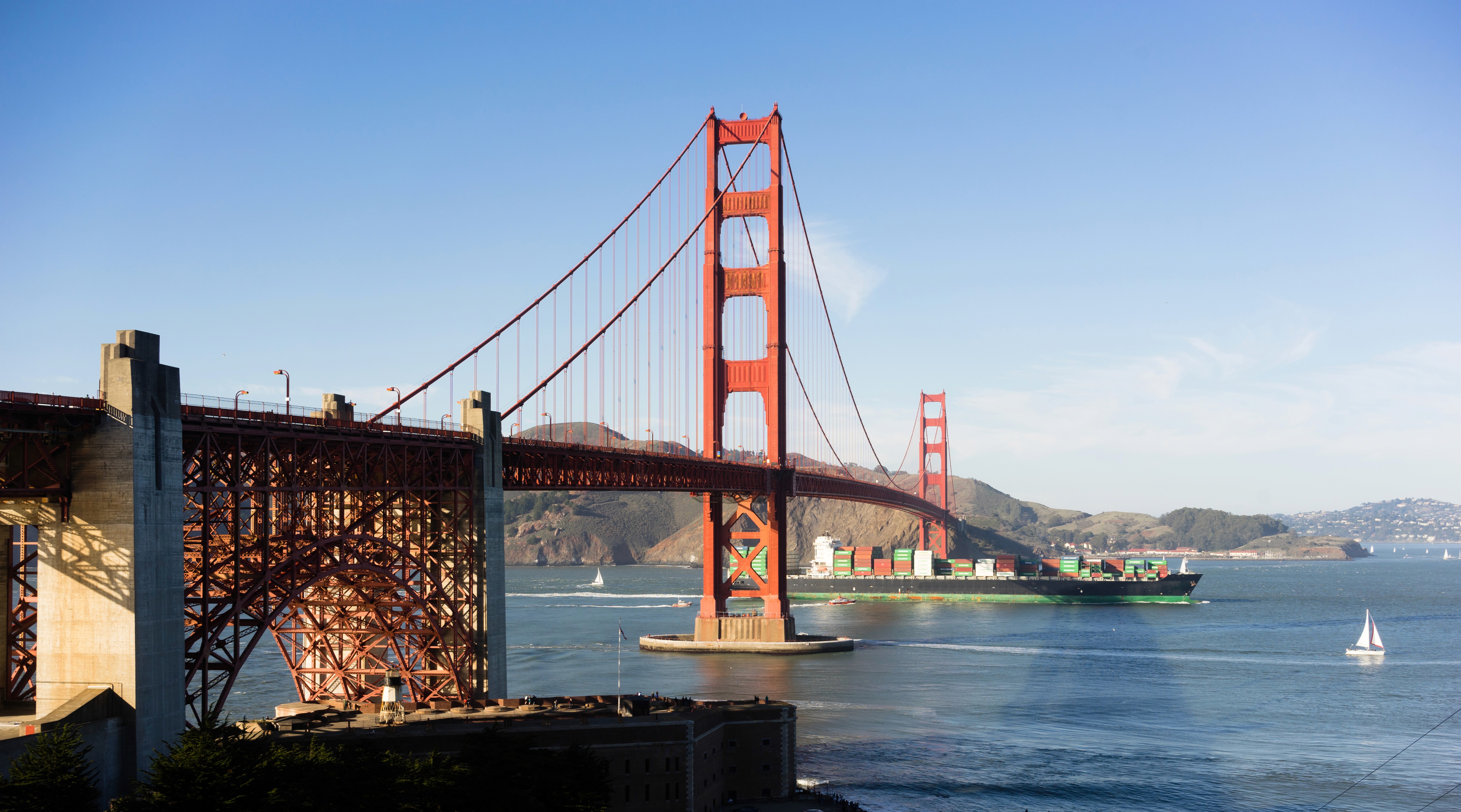 Side view of the San Francisco Golden Gate bridge against blue sky.