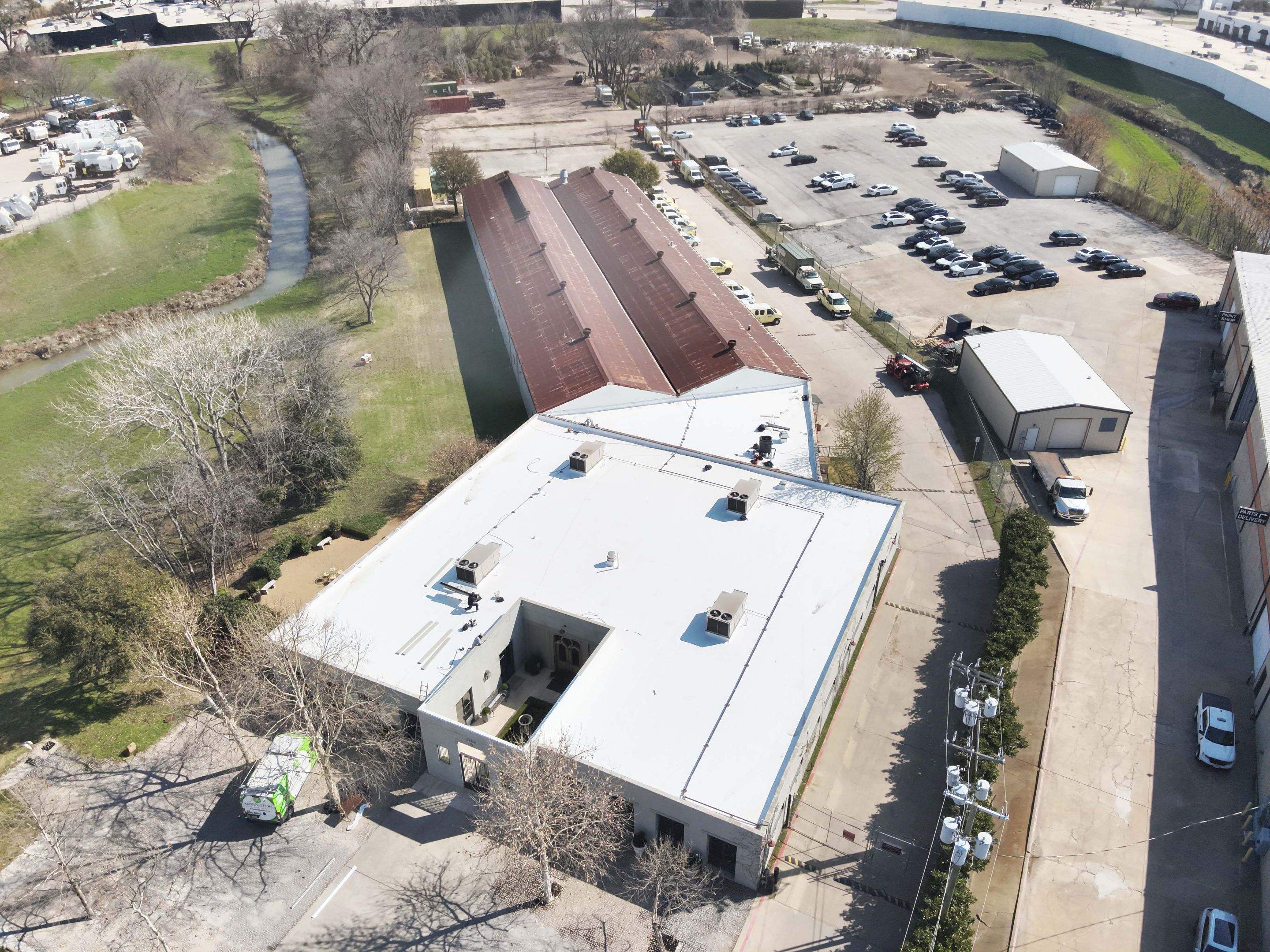 Mid-project view of the crew installing the white TPO single-ply membrane on the Dallas commercial roof