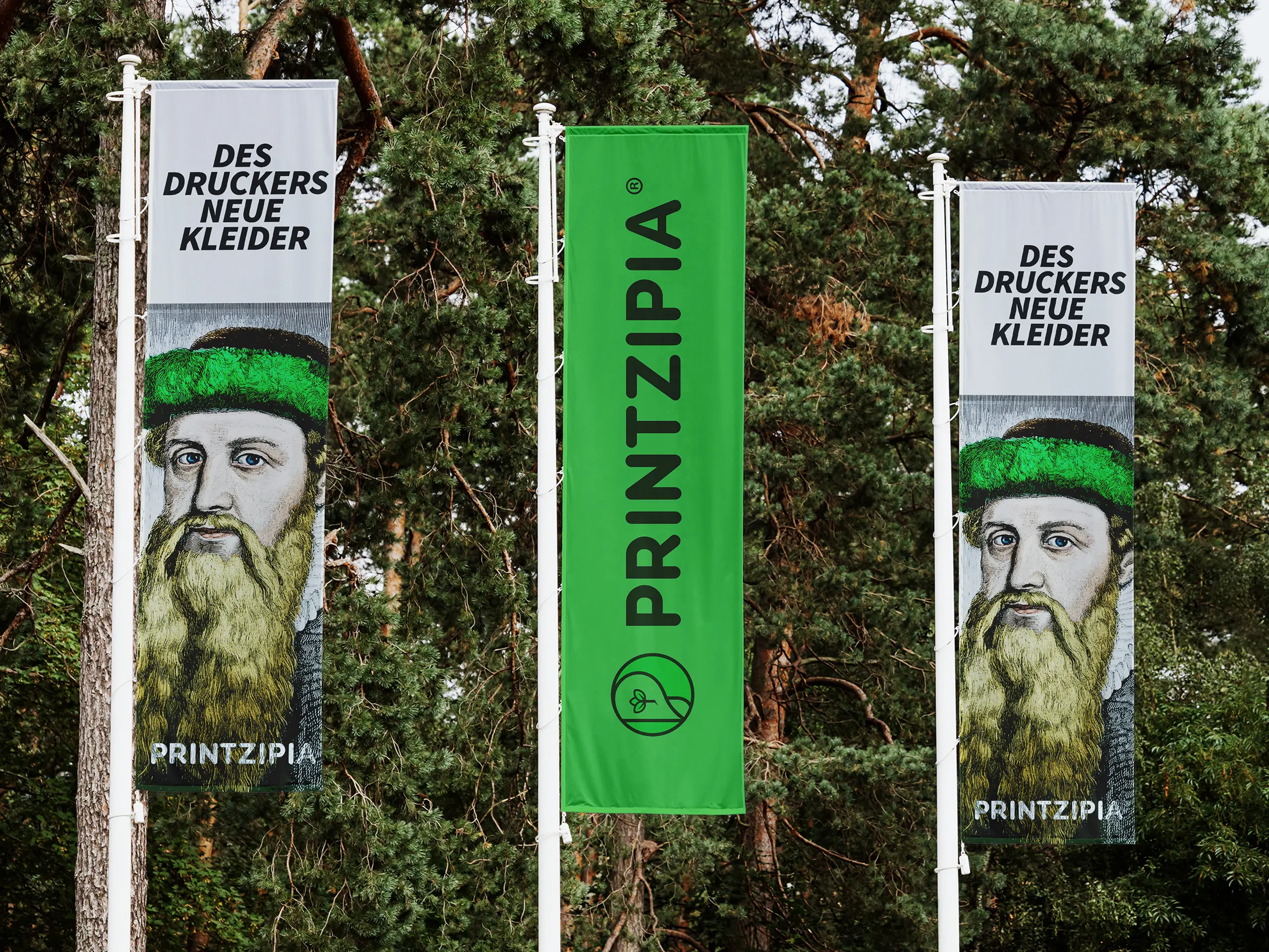 Drei Banner Printzipia vor Nadelwald mit Gutenberg-Motiv und grünem Branding