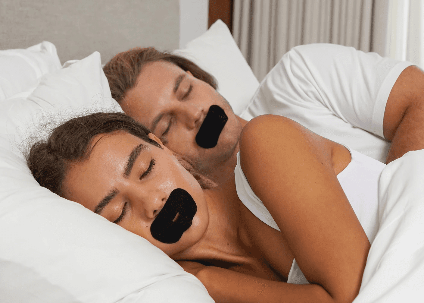 A couple sleeping with SleepSeal premium mouth tape allowing them to sleep deeper