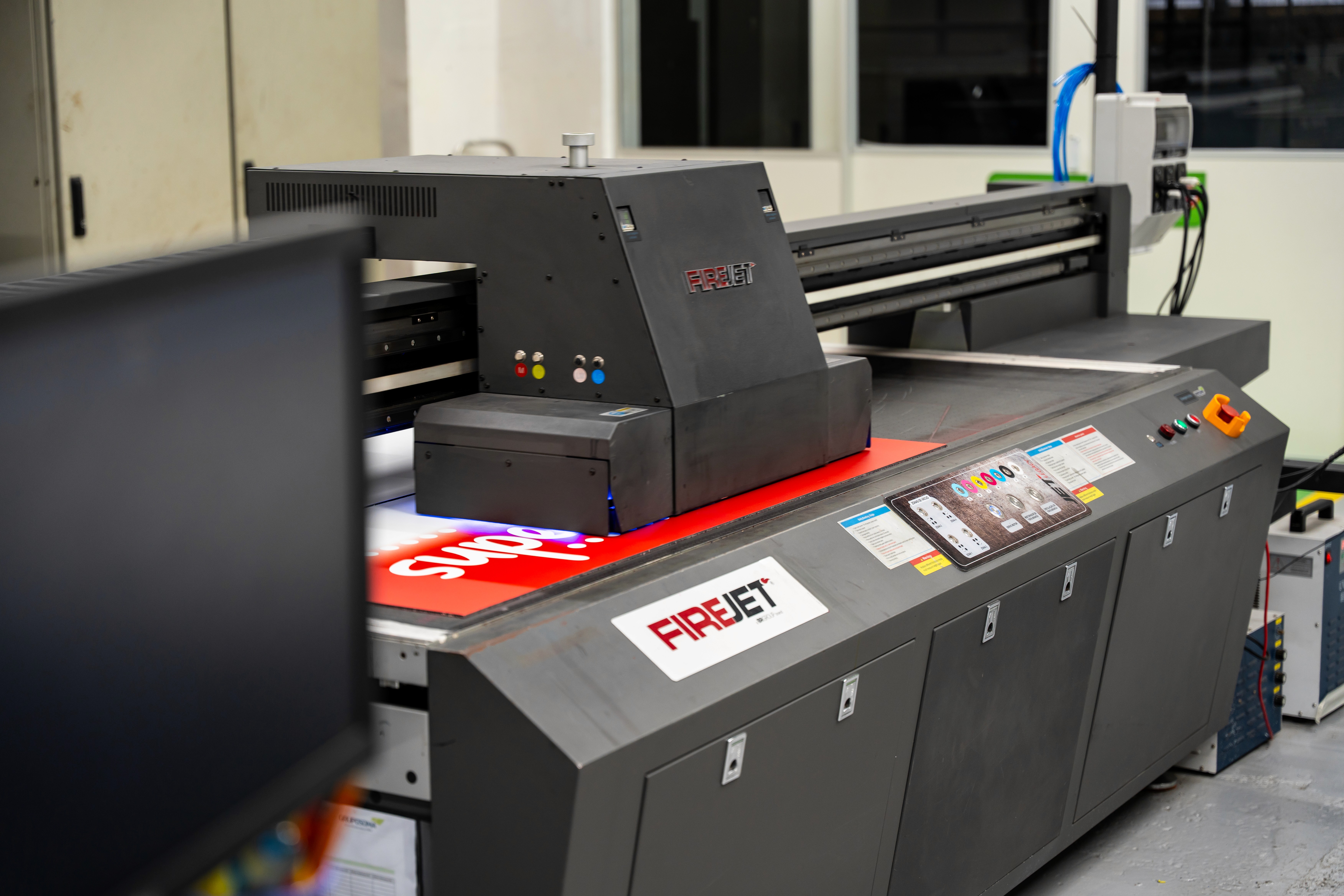 Four diverse professionals collaboratively working on a laptop, with one person pointing at the screen while others observe.