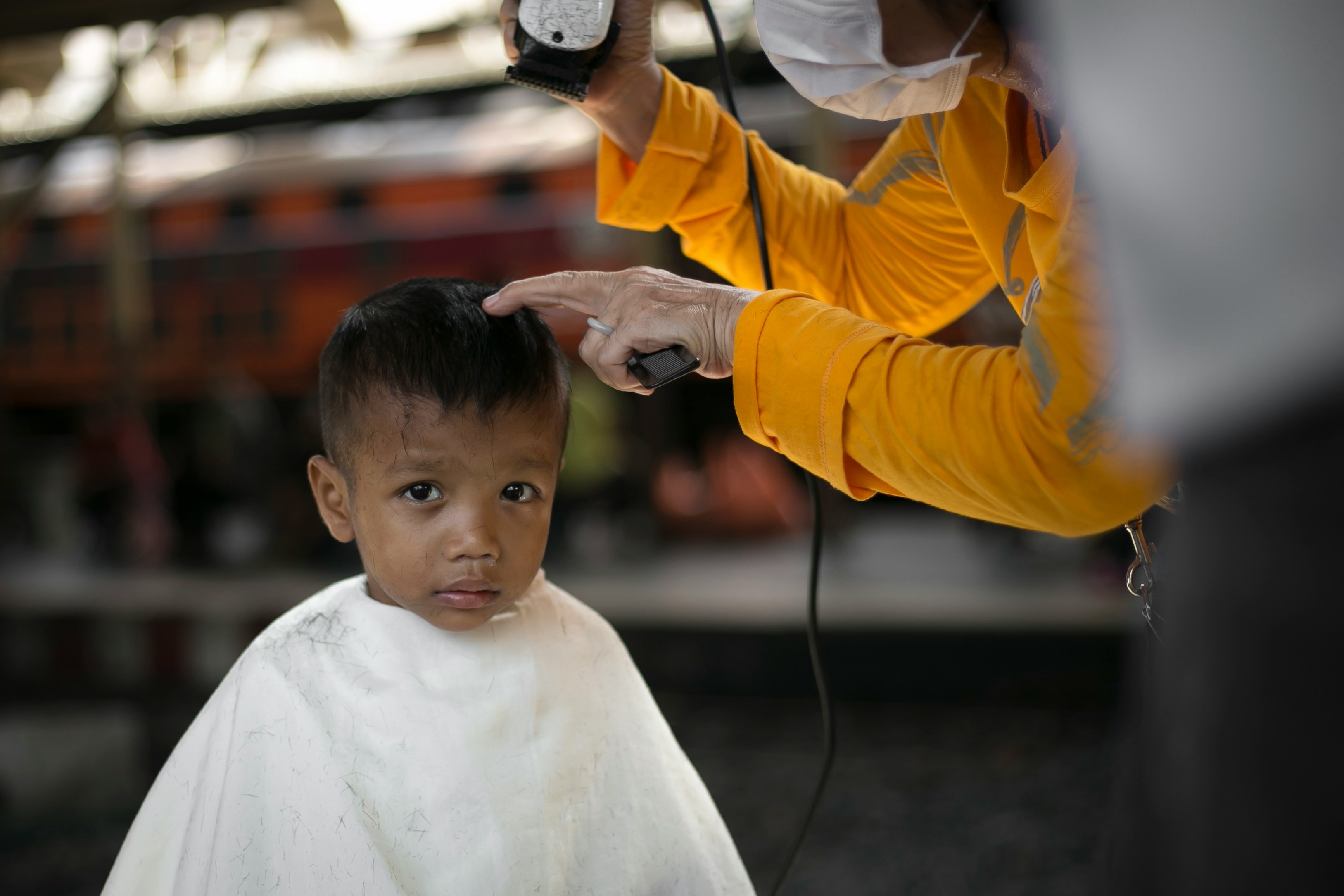 man cutting hair of boy