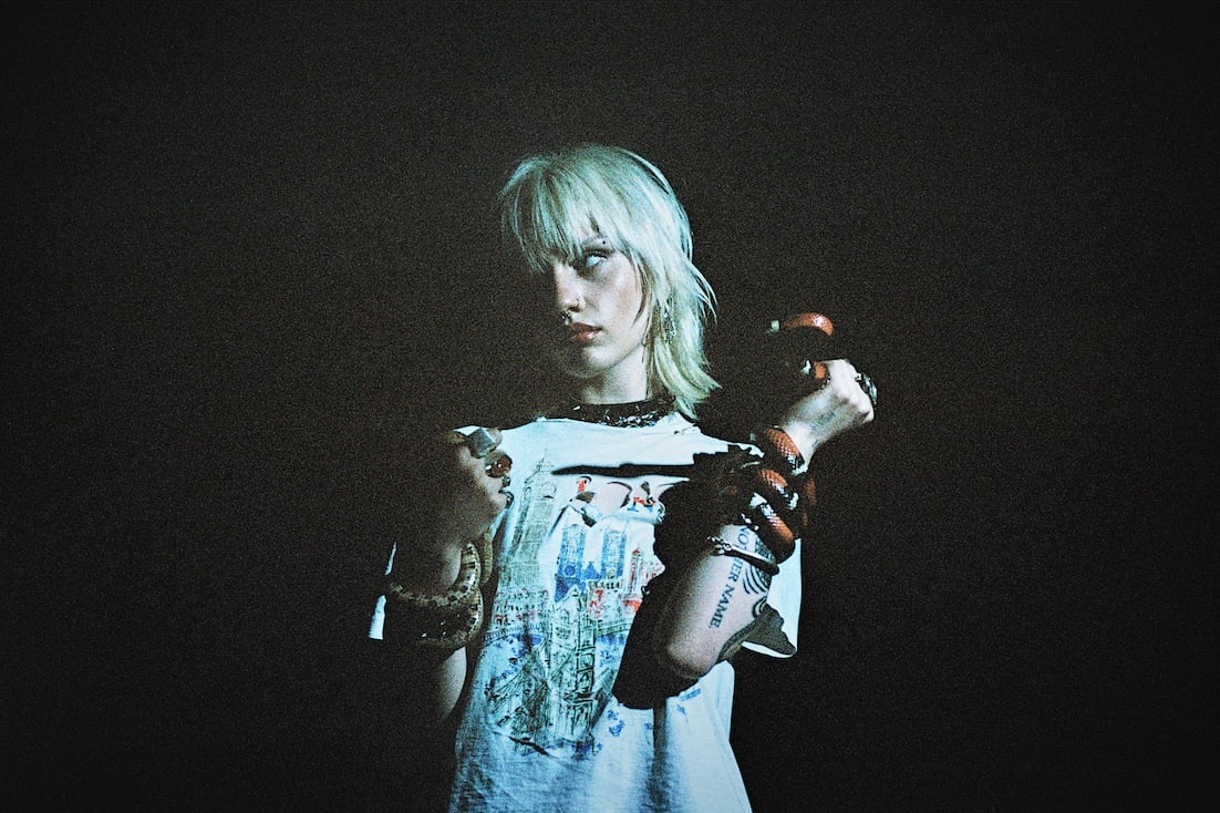 Two people installing or adjusting abstract blue artworks on a gallery wall 