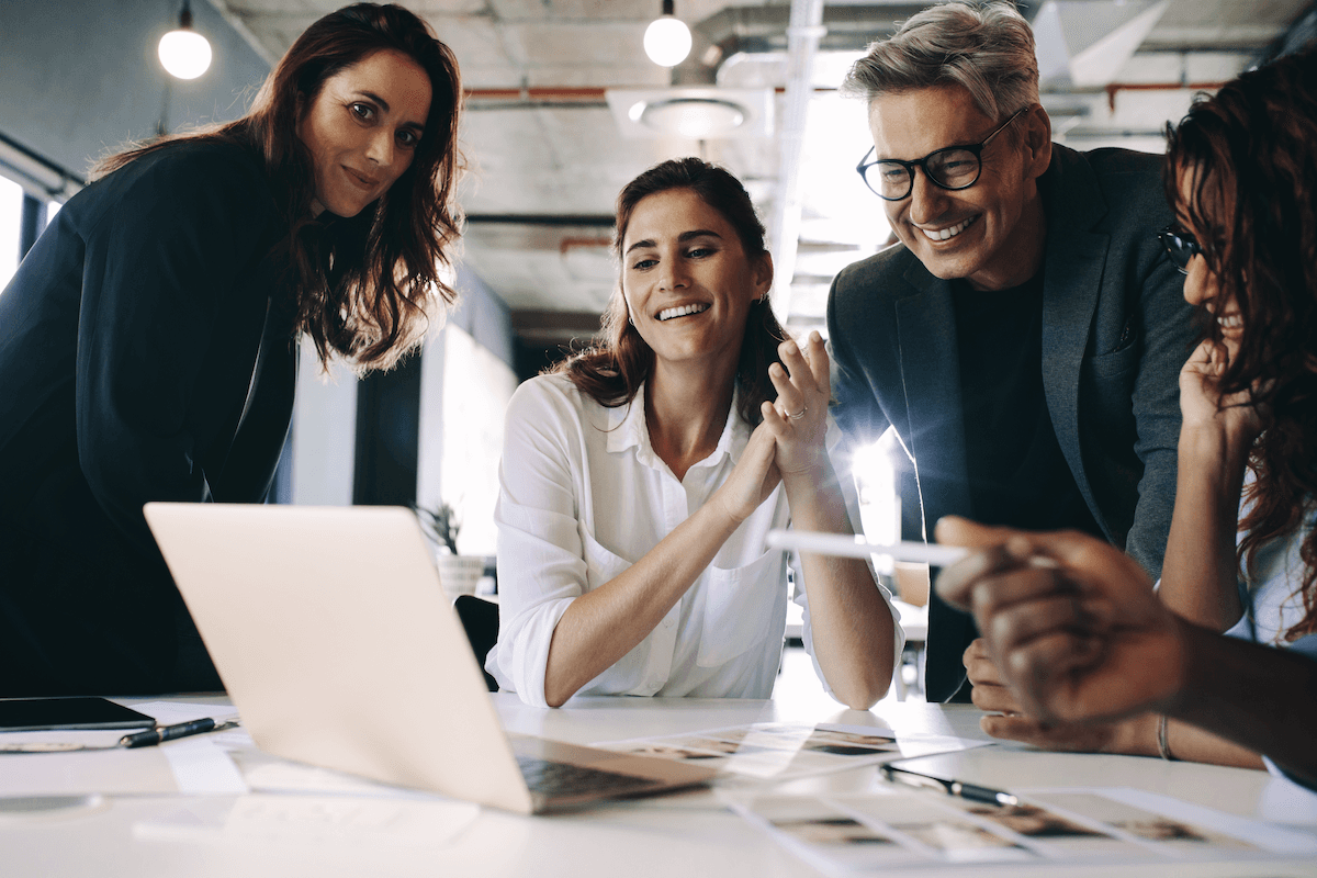 sales support: Group of people smiling while looking at a laptop screen