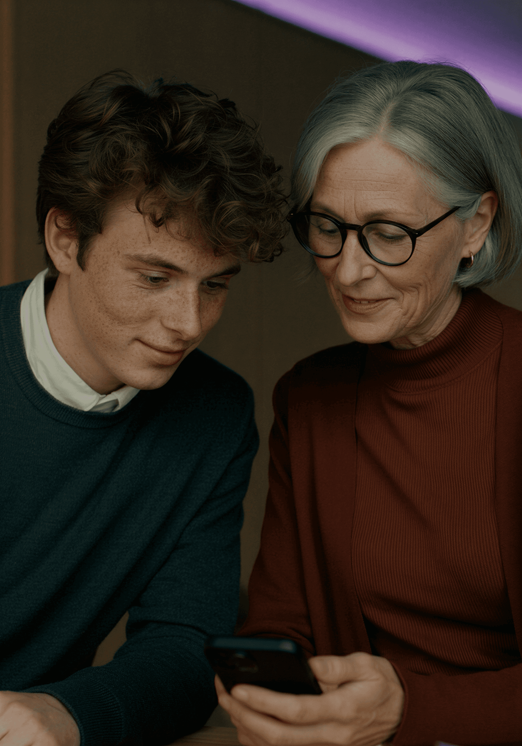 Man talking animatedly on the phone while sitting on couch.