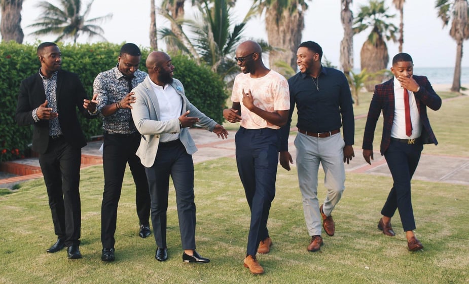 Six dapper gentlemen standing on a lawn