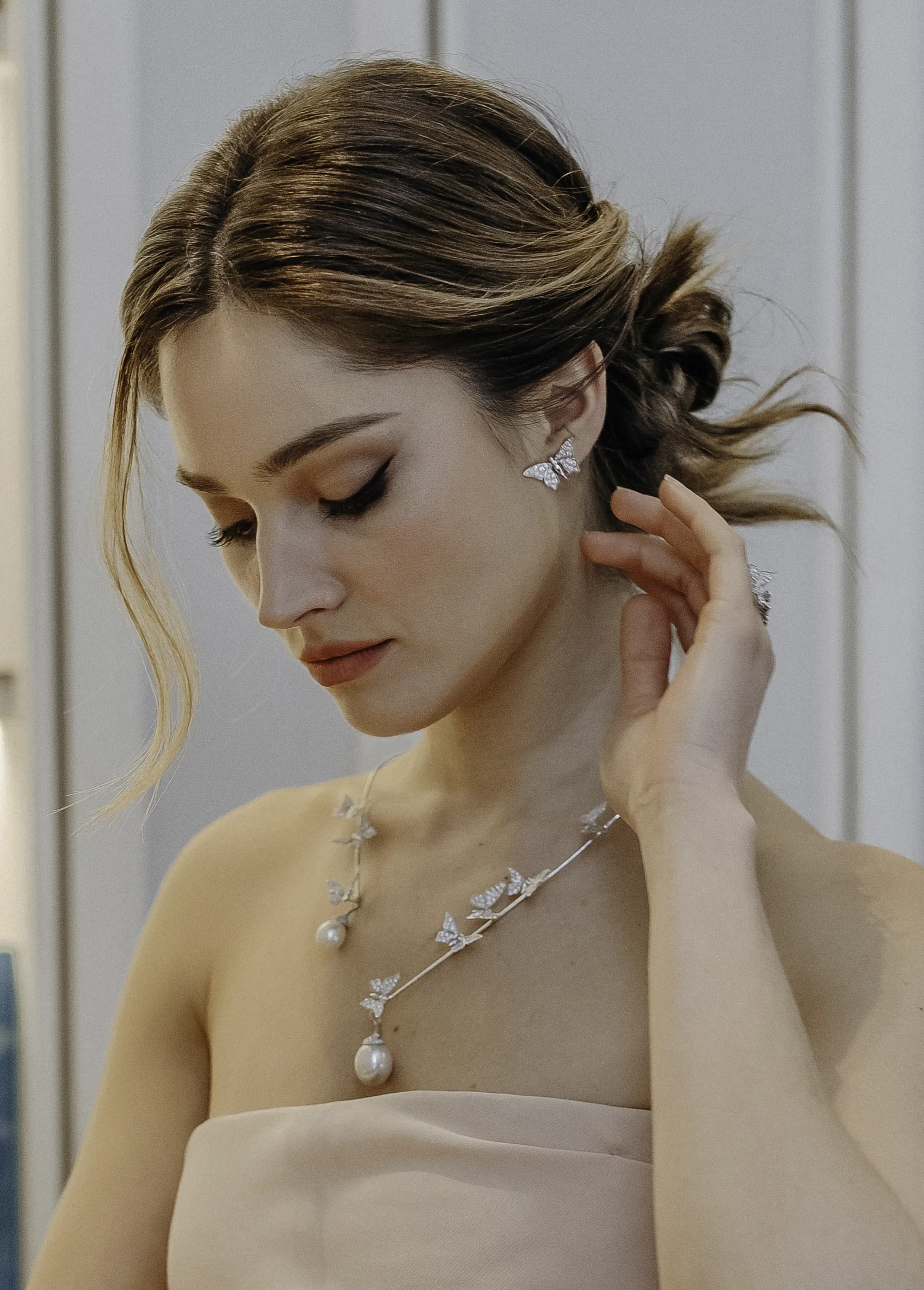 Boucles d’oreilles Papillons Maison Édéenne portées aux oreilles avec une robe claire