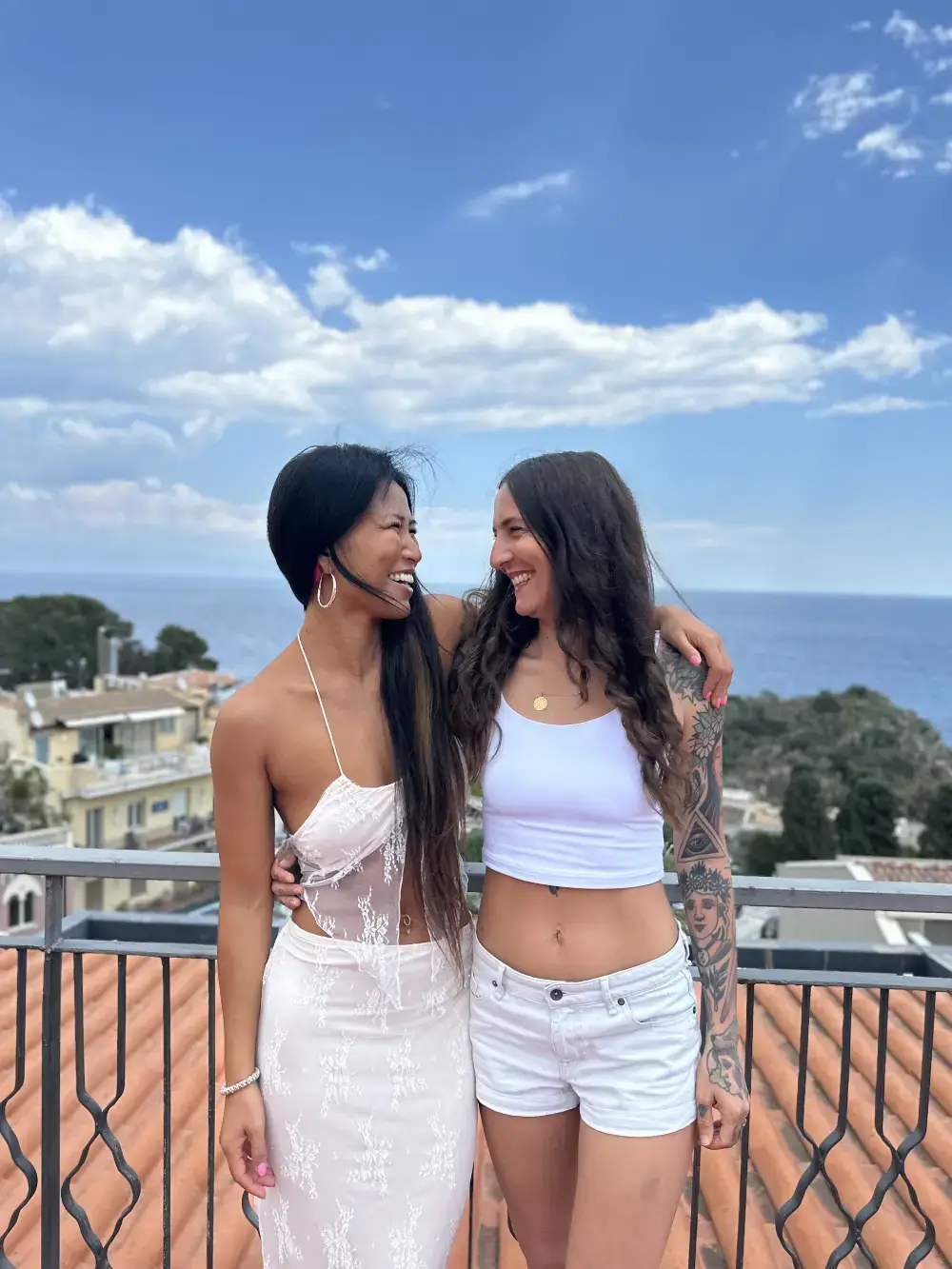 Two students practicing partner yoga and backbends outdoors by a lotus pond in Bali.