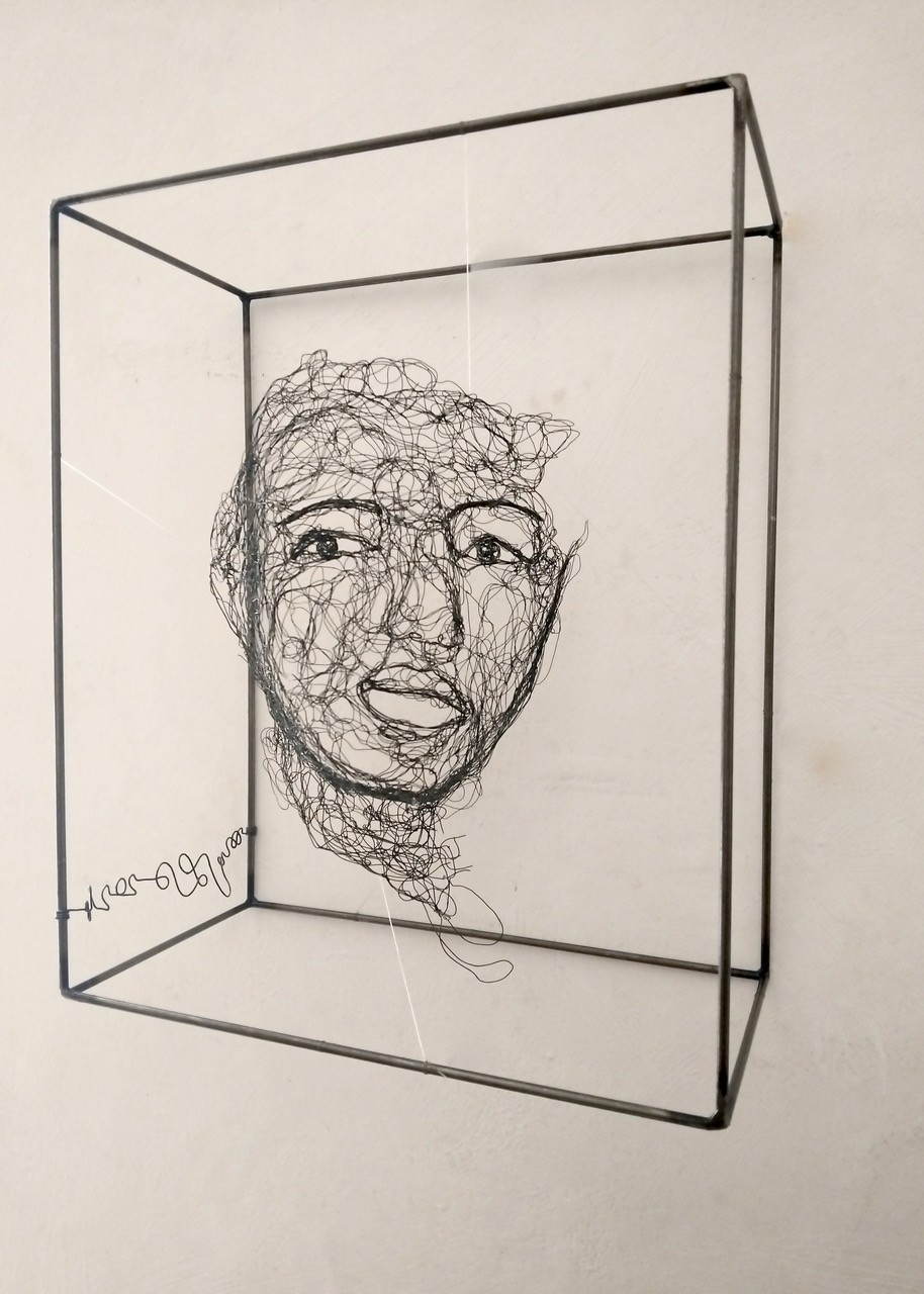 Sculpture en fil de fer représentant le visage d'une femme dans un cadre en fil de fer, vue détaillée de profil