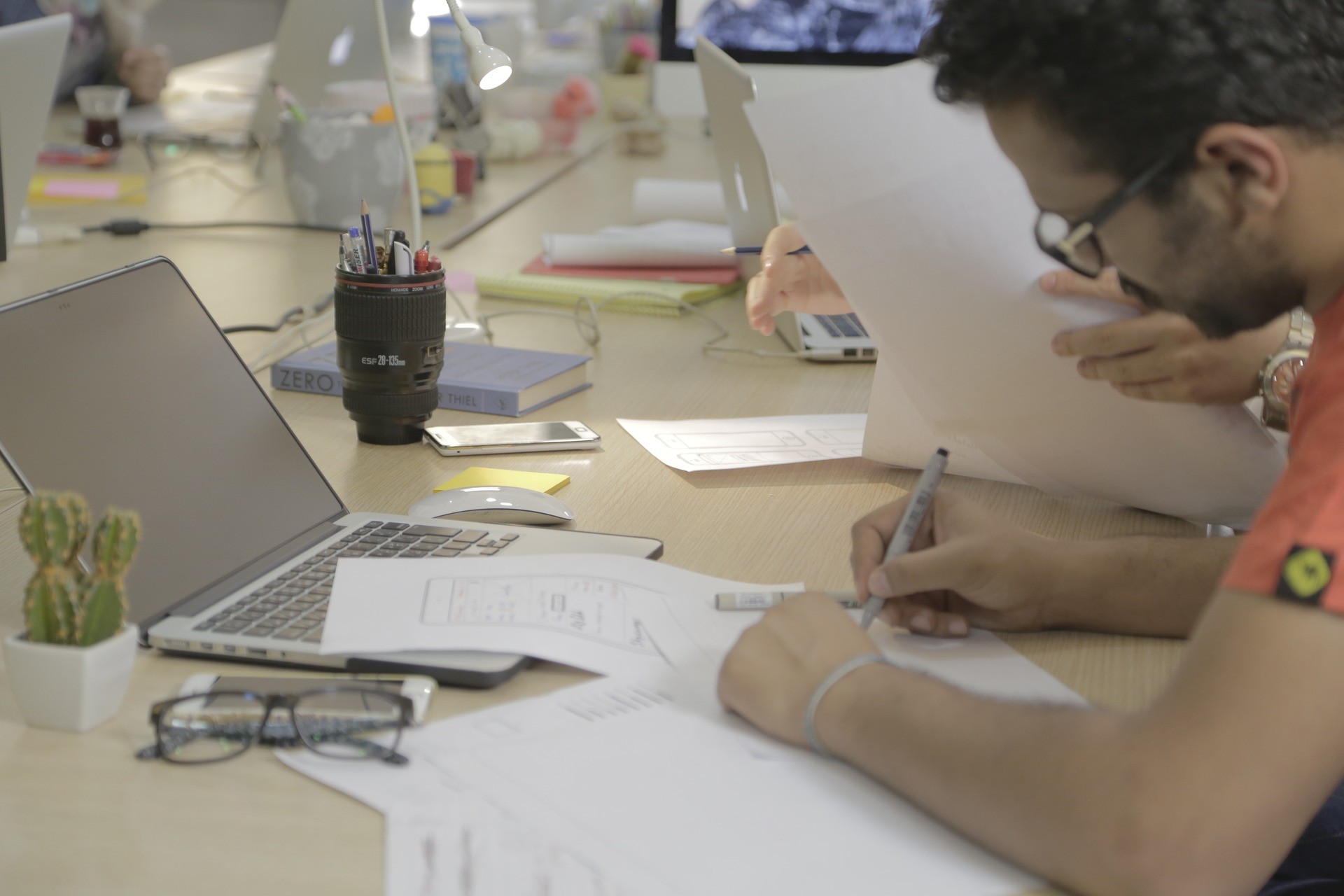 Two team members annotating printed wireframes together at a shared desk
