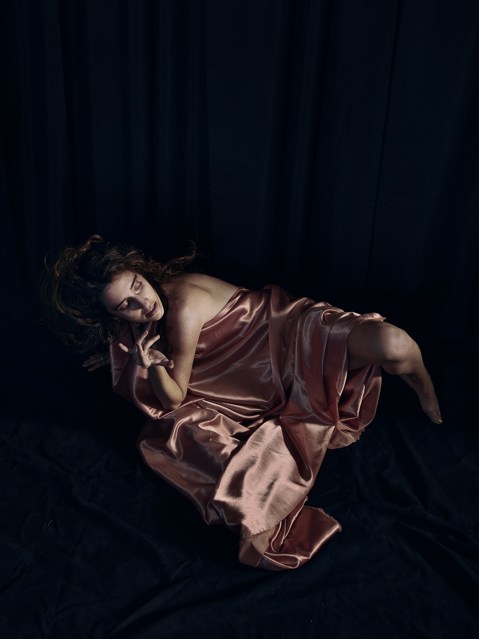 Dancer captured mid performance with artistic and expressive movements against a dark background.