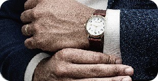 man in blue suit jacket wearing gold round analog watch