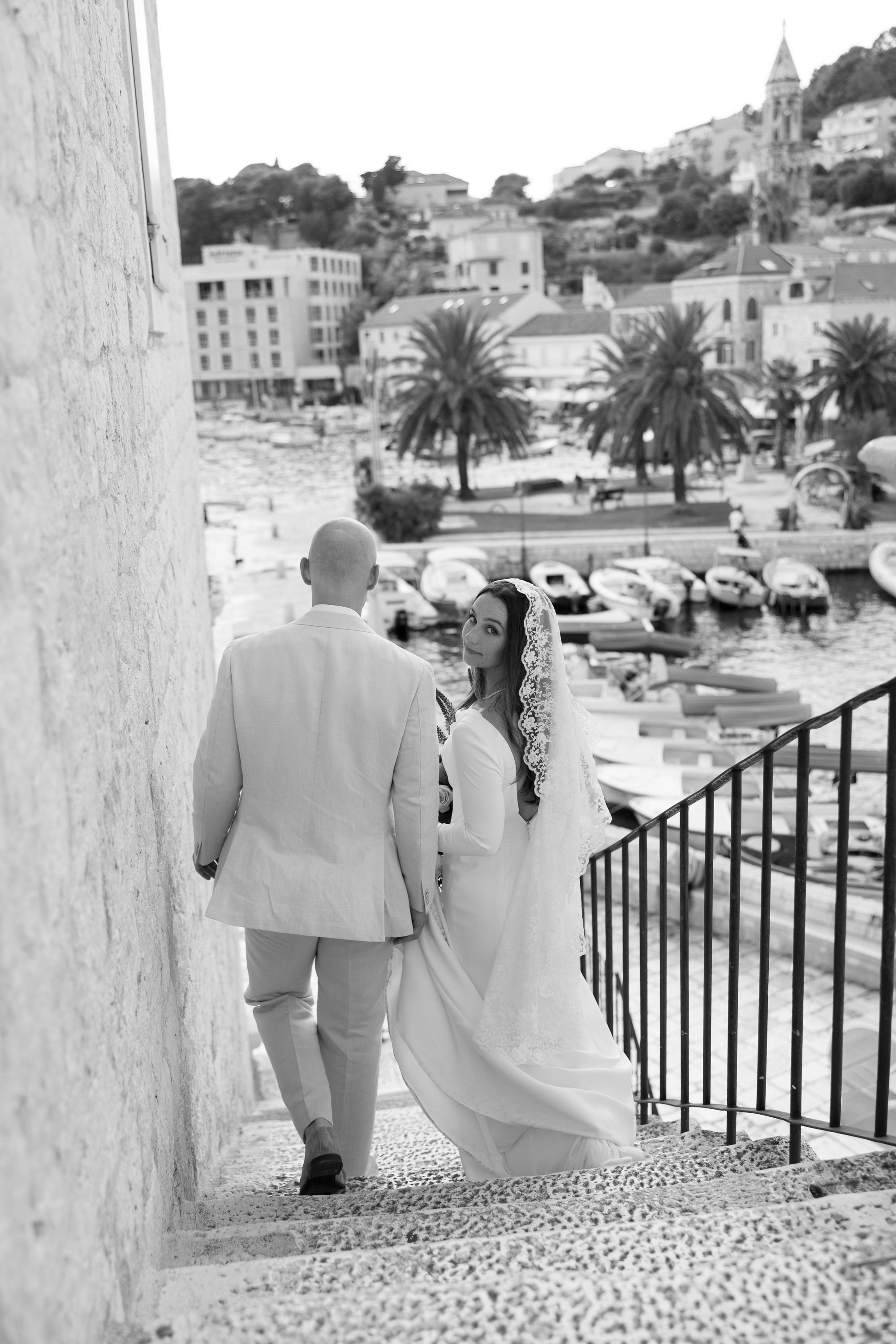 Bride and groom walking down the stairs with bride looking back over her shoulder