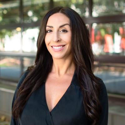 Two young women interact with a horse at a stable.