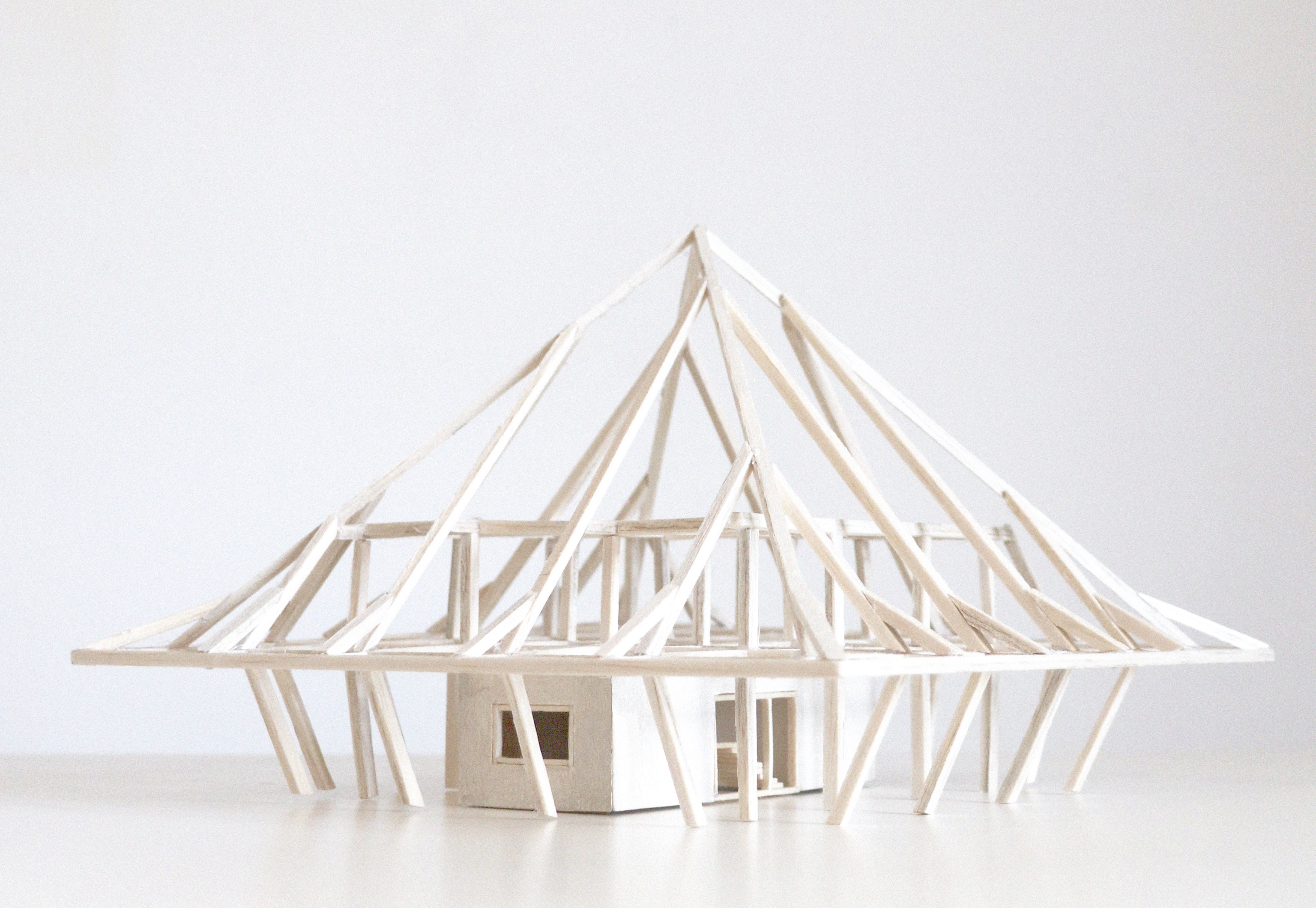 A modern, minimalist interior with wooden flooring, large windows, and a few plants giving a bright, airy feel.