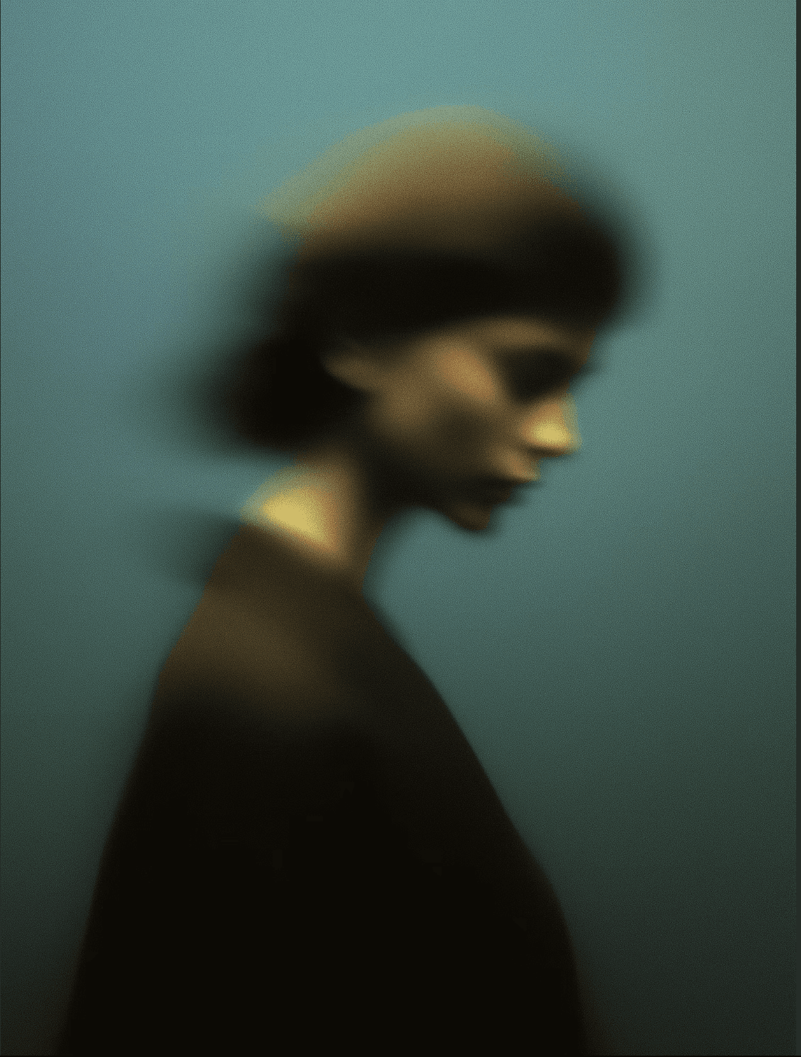Soft-focus side profile of a person against a teal background