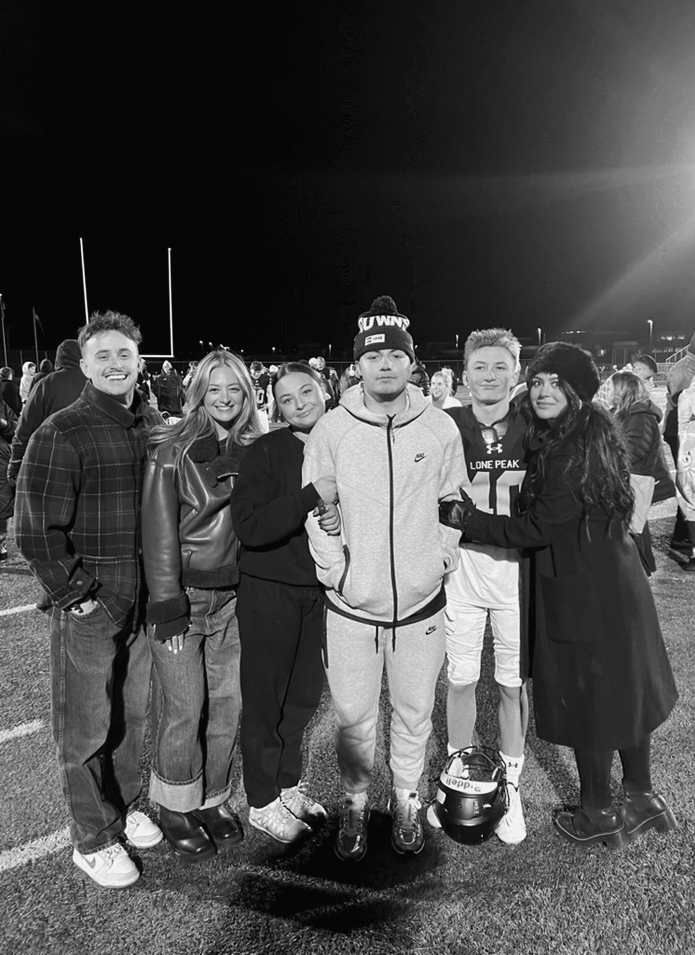 A woman with straight blonde hair wearing a light colored sweater looks away.