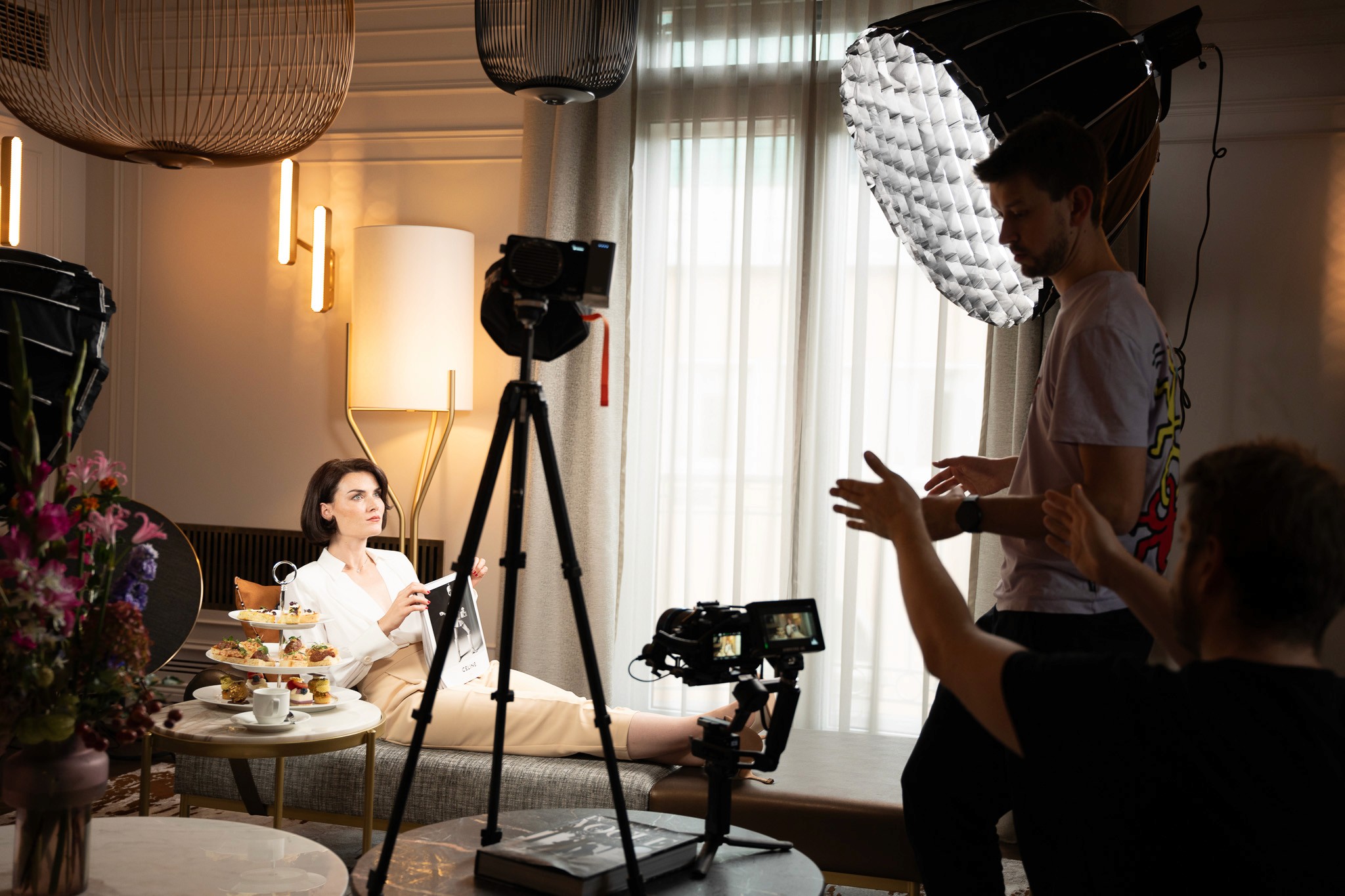 Videographer directing a scene, in a hotel with multiple lights in a luxiurious hotel