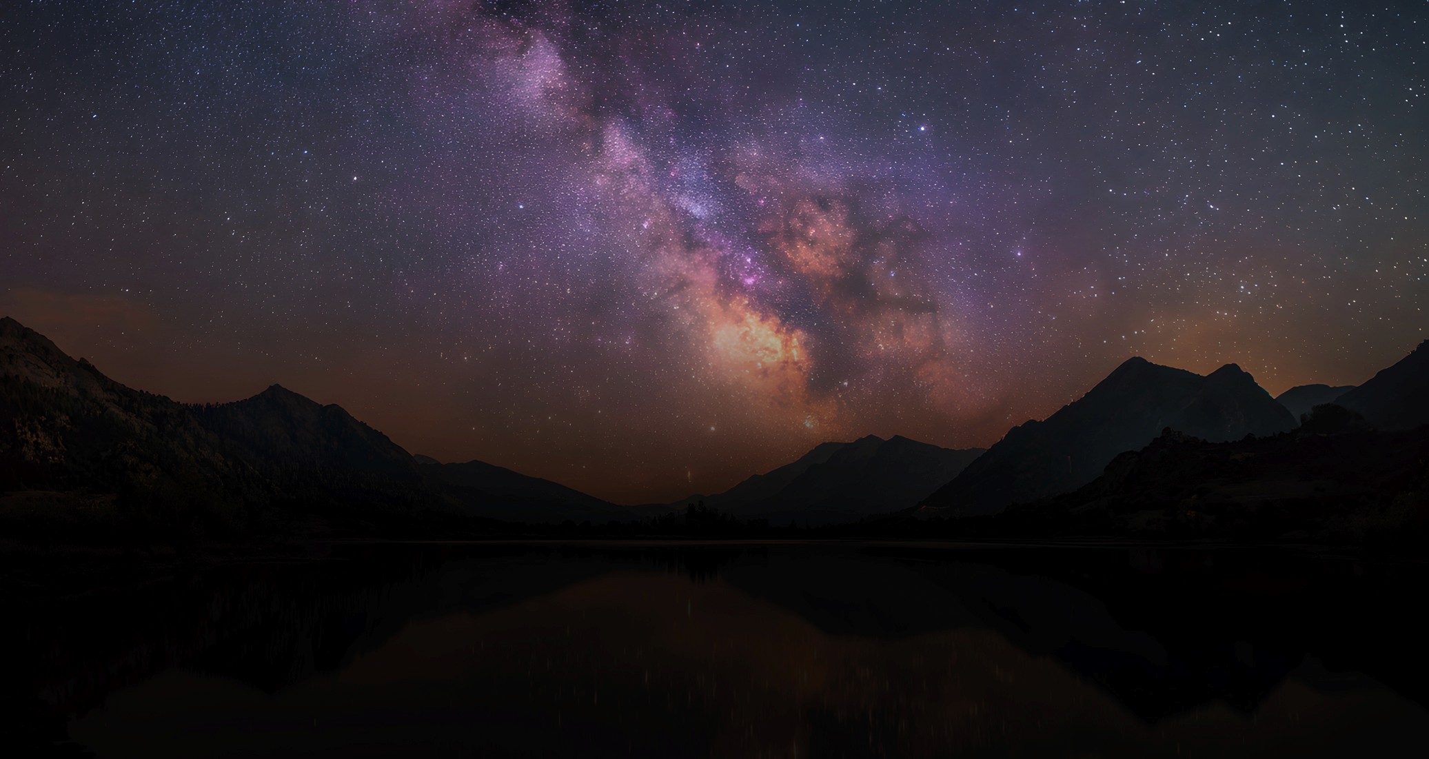 mountain lake at dusk with the milky way in the sky