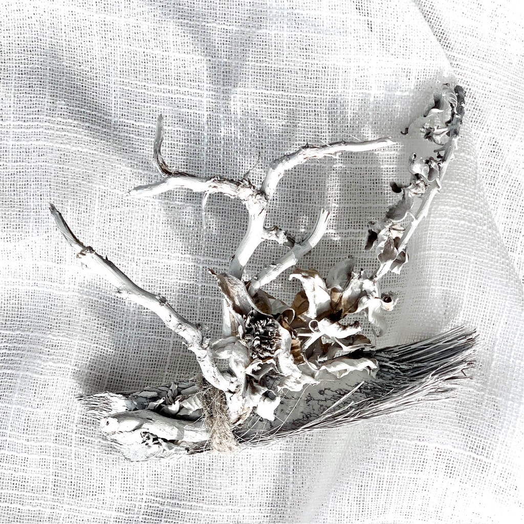 Artistic floral composition combining driftwood, dried blooms, and subtle tone variations