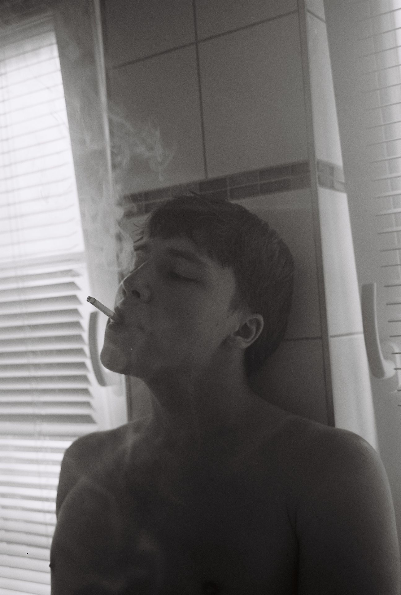 man with cigarette smoking in bathroom