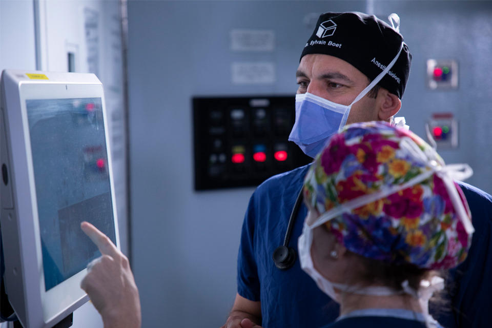 Surgeons in operating room looking at screen