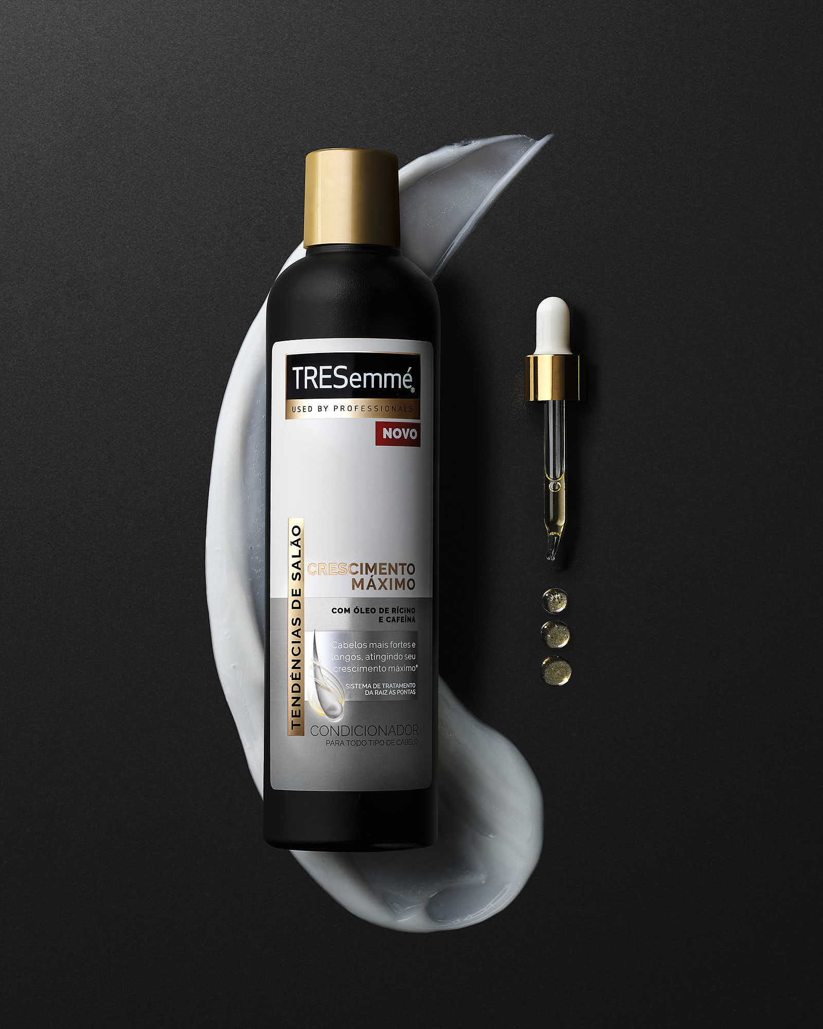 TREsemmé Crescimento Máximo conditioner with serum and dropper on black background.