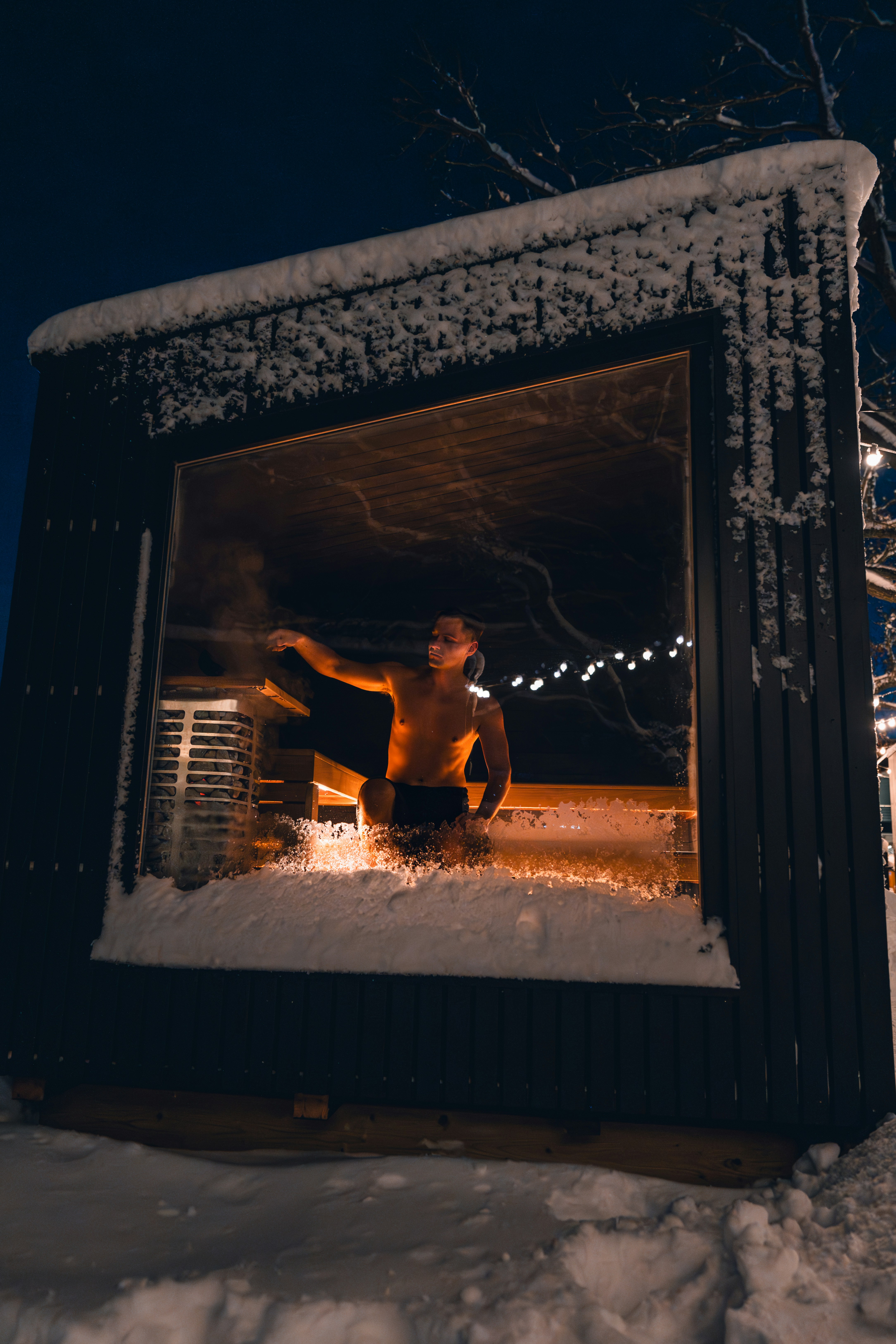 A man standing in the window of a building covered in snow