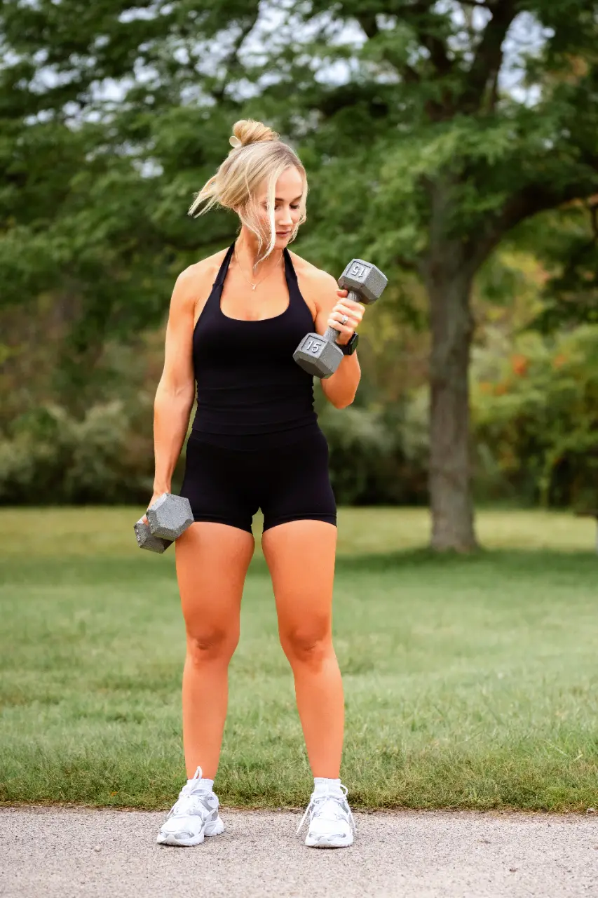 Woman carrying work and gym bags in a black Aspire Athleisure set