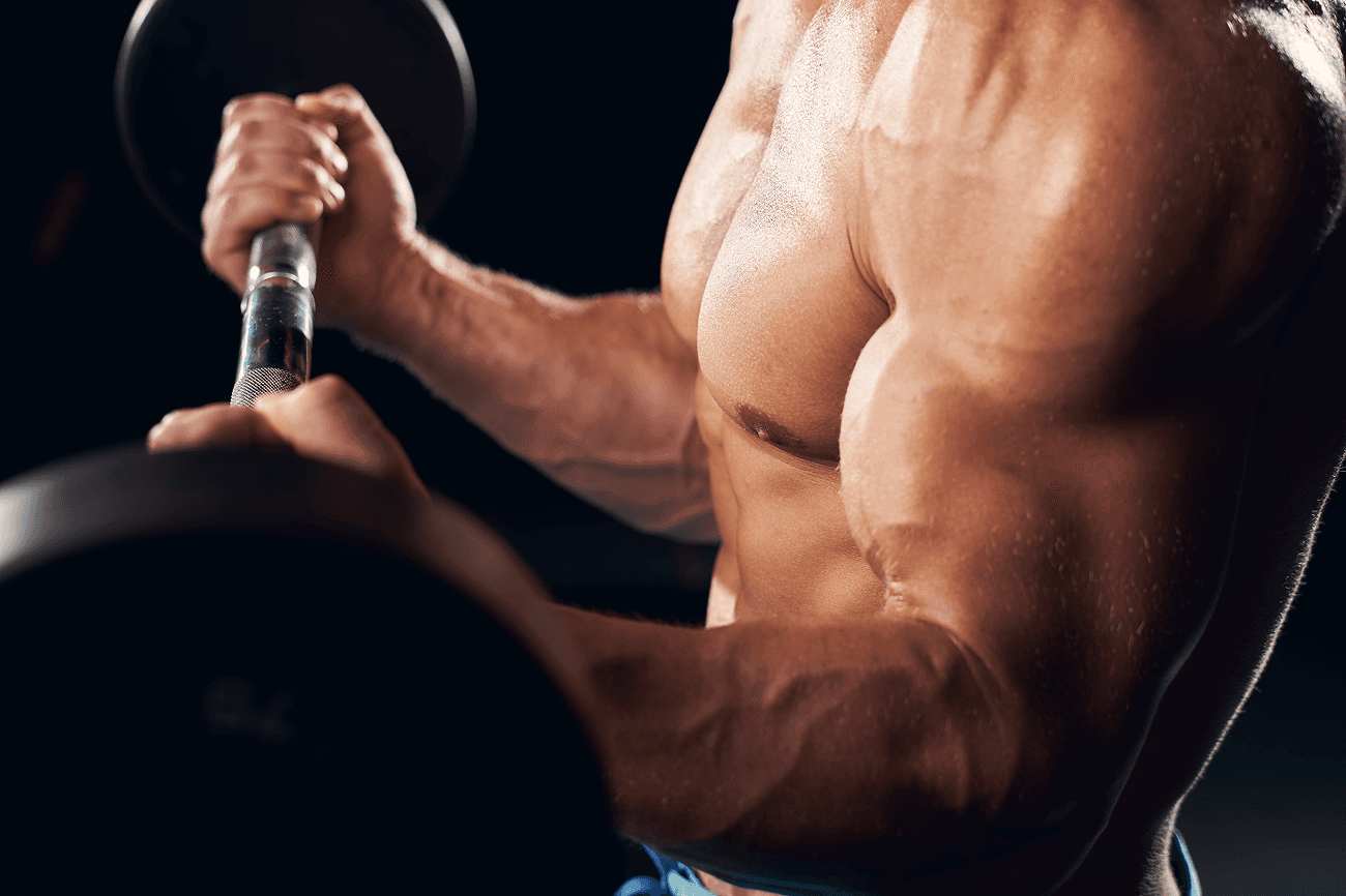 Close-up of a muscular man lifting a barbell, highlighting his chest and arm muscles.