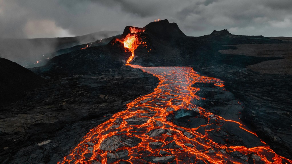 Lava flowing over black and brown rocks