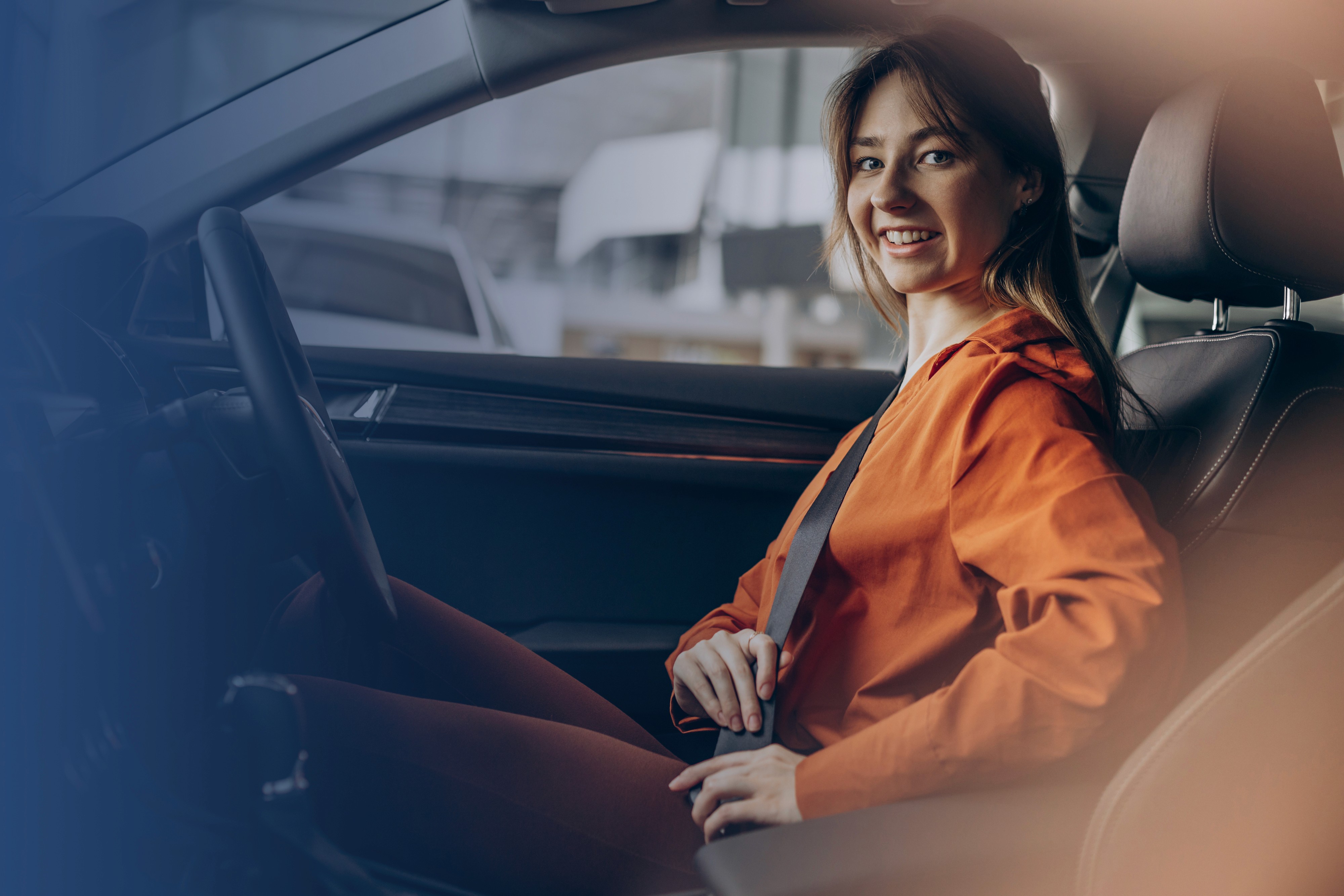 Woman sitting in a car fastening her seat belt
