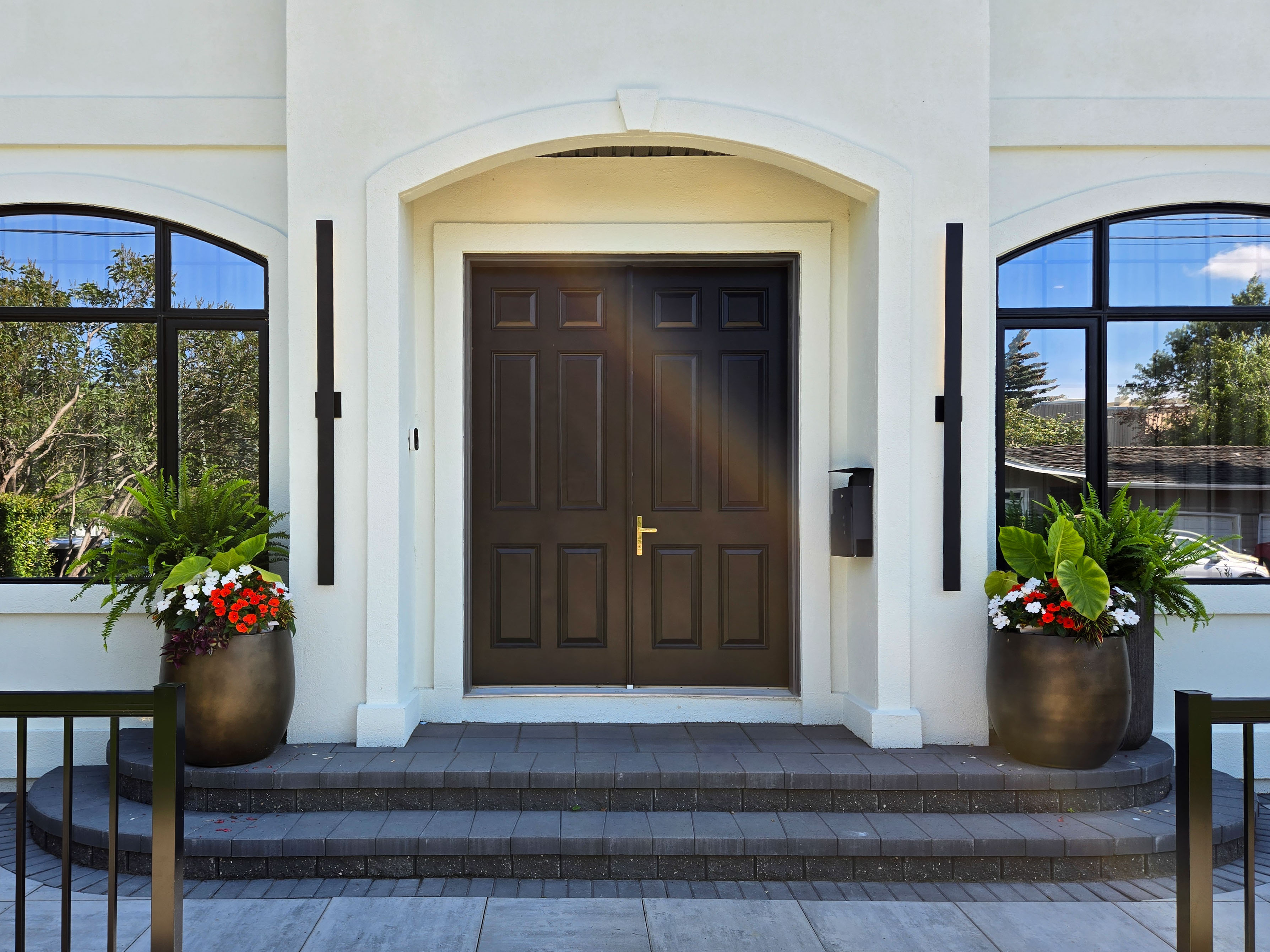 Image of KHD Homes exterior design with luxurious front entrance, large windows, and decorative planters.