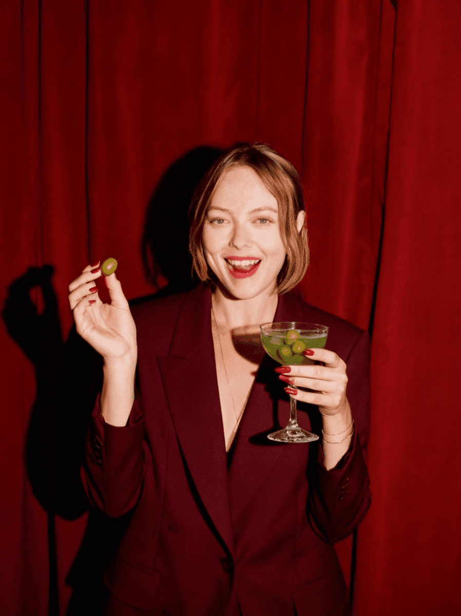 Smiling woman holding olive cocktail.