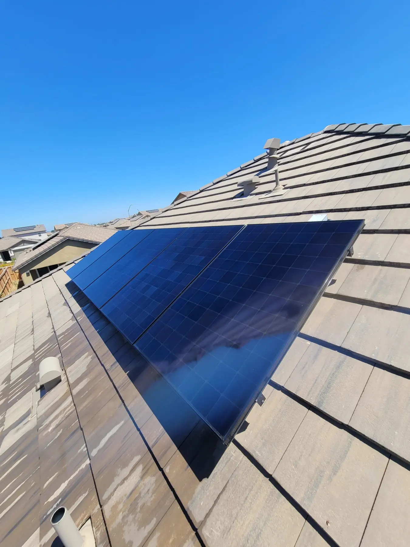 Rooftop solar panels at a building edge, seen from below | Premier Solar Service, serving Fresno, CA