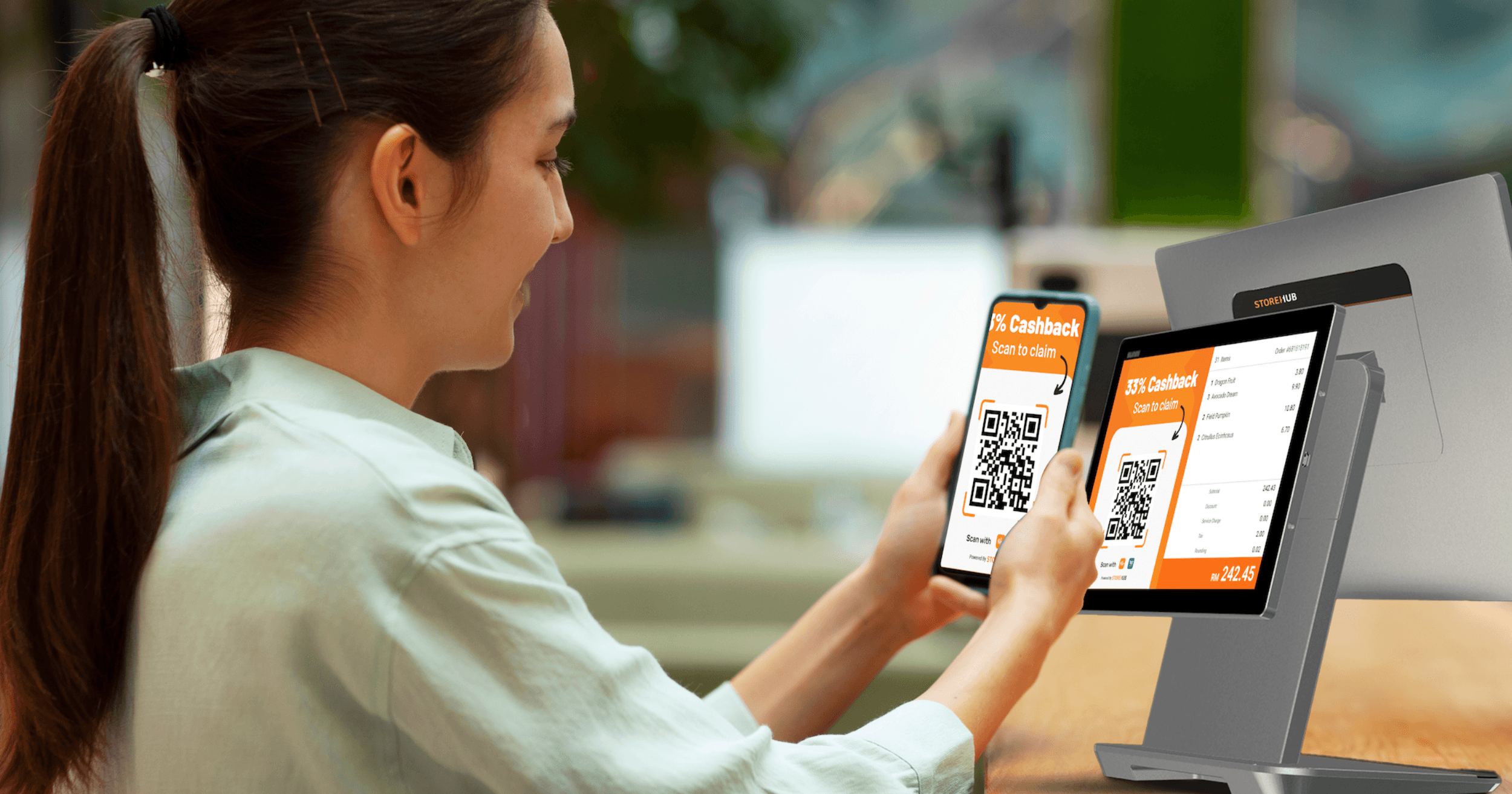 eorang pelanggan sedang mengimbas kod QR pada sistem POS StoreHub