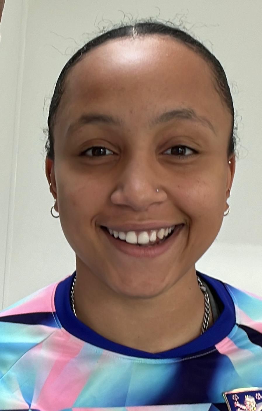 woman wearing black off-shoulder top with left hand under chin during daytime