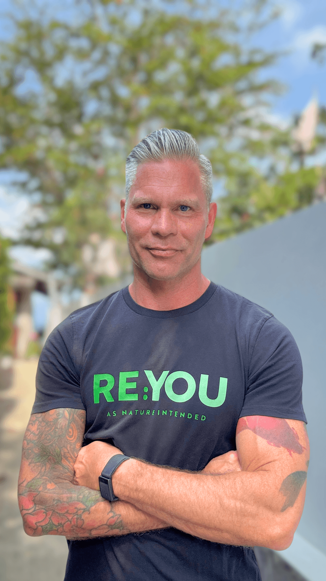 Johannes Cullberg står på en strand, ler och tittar mot kameran med armarna i kors