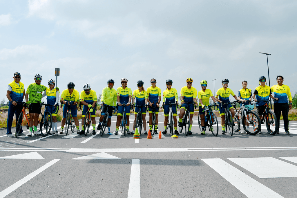 Equipo de ciclistas zenbike posando en fila sobre la carretera con uniformes amarillo y azul.