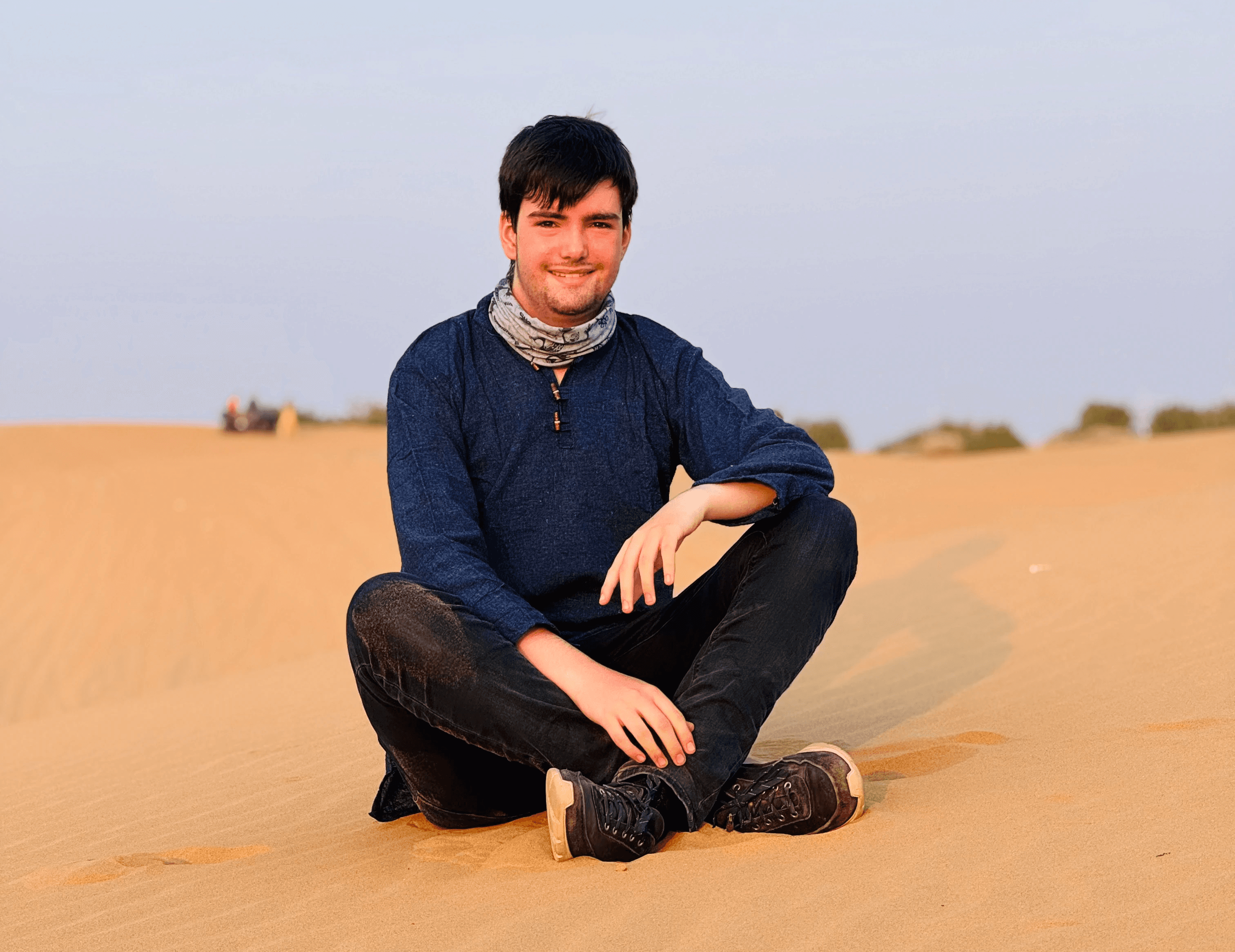 An image of Lennard Dorst sitting on a sand dune. Shot in Rajasthan, India, 2024.