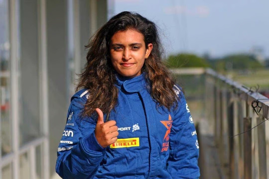 Pragathi Gowda in her racing suit with a thumbs up